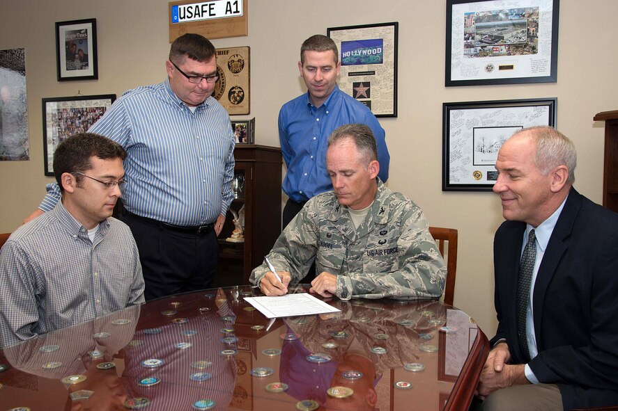 Col. Michael A. Vogel, 66th Air Base Group commander, recognizes October as Energy Action Month at Hanscom by signing a proclamation in Building 1305 Sept. 25 as (left to right) David Wong, Mike Lynch, Brian Noury and Thomas Schluckebier look on.  October is Energy Action Month and as part of a national campaign, led by the Department of Energy, Hanscom provides an opportunity to promote energy and water conservation awareness to the community. (U.S. Air Force photo by Mark Herlihy)