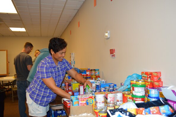 Brenda Lewis of Air Forces Northern’s Installations & Mission Support Directorate helps sort donated food during the annual Homeless Veterans Stand Down Sept. 25 at the Family Life Center of First Baptist Church in Panama City. Approximately 120 veterans attended the event which featured medical services, Veterans Affairs and housing assistance. The veterans were also provided military backpacks which they filled with a variety of items from socks to sunglasses. (Photo by Mary McHale)