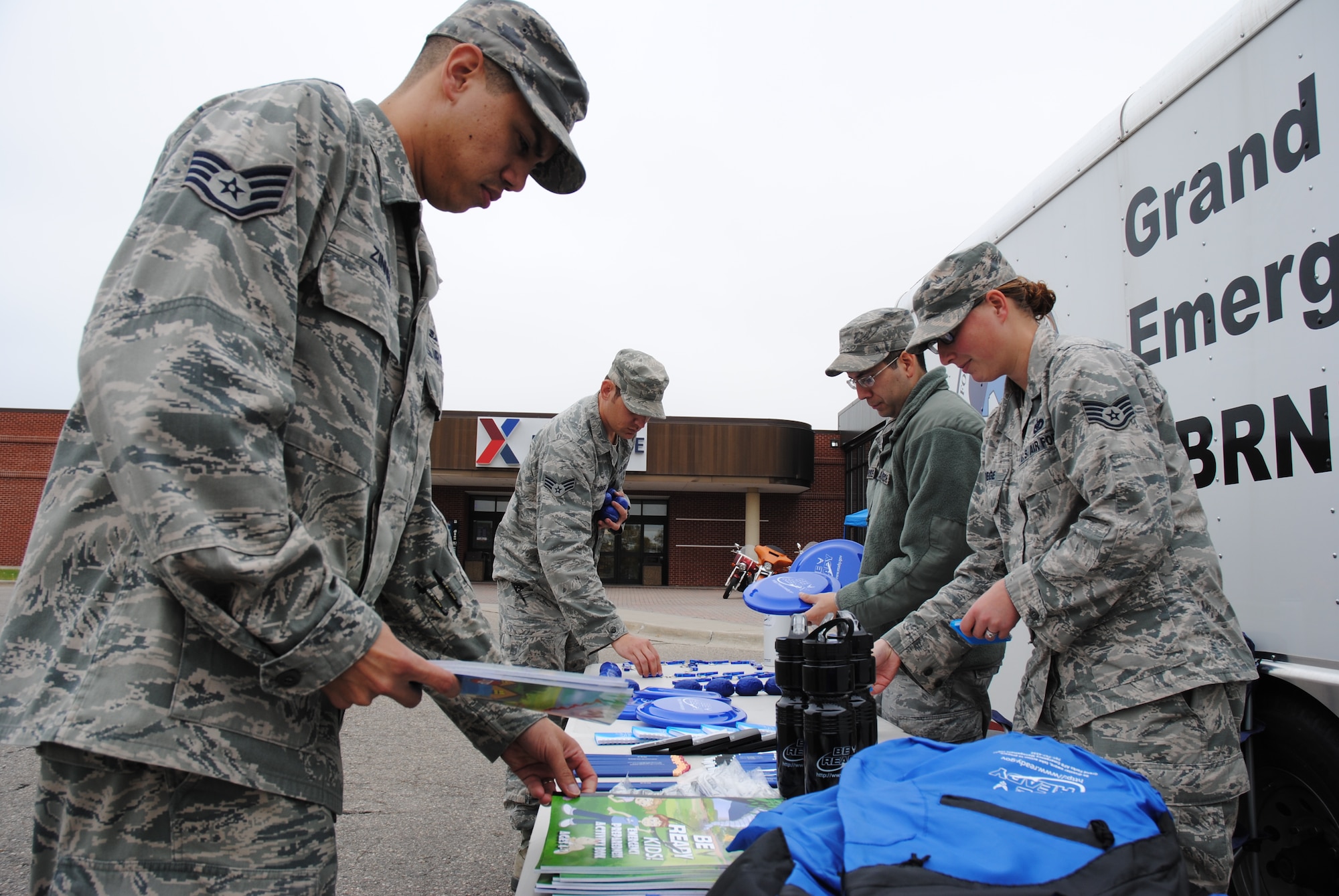 Staff Sgt. Shaun Zinner, Senior Airman Scott Tucker, Senior Airman Jaime Barrientos and Staff Sgt. Samantha Strege from the 319th Civil Engineering Squadron’s Emergency Management Flight prepare their information booths with goodies, educational materials on National Preparedness Month Sept. 25, 2014, in the Exchange parking lot on Grand Forks Air Force Base, N.D. National Preparedness Month is a part of a governmental effort to strengthen the United States' preparedness capabilities. The national preparedness architecture encompasses prevention, protection, response, and recovery efforts to prepare the United States for all hazards – whether terrorist attack or natural disaster. (U.S. Air Force photo/Staff Sgt. Luis Loza Gutierrez)