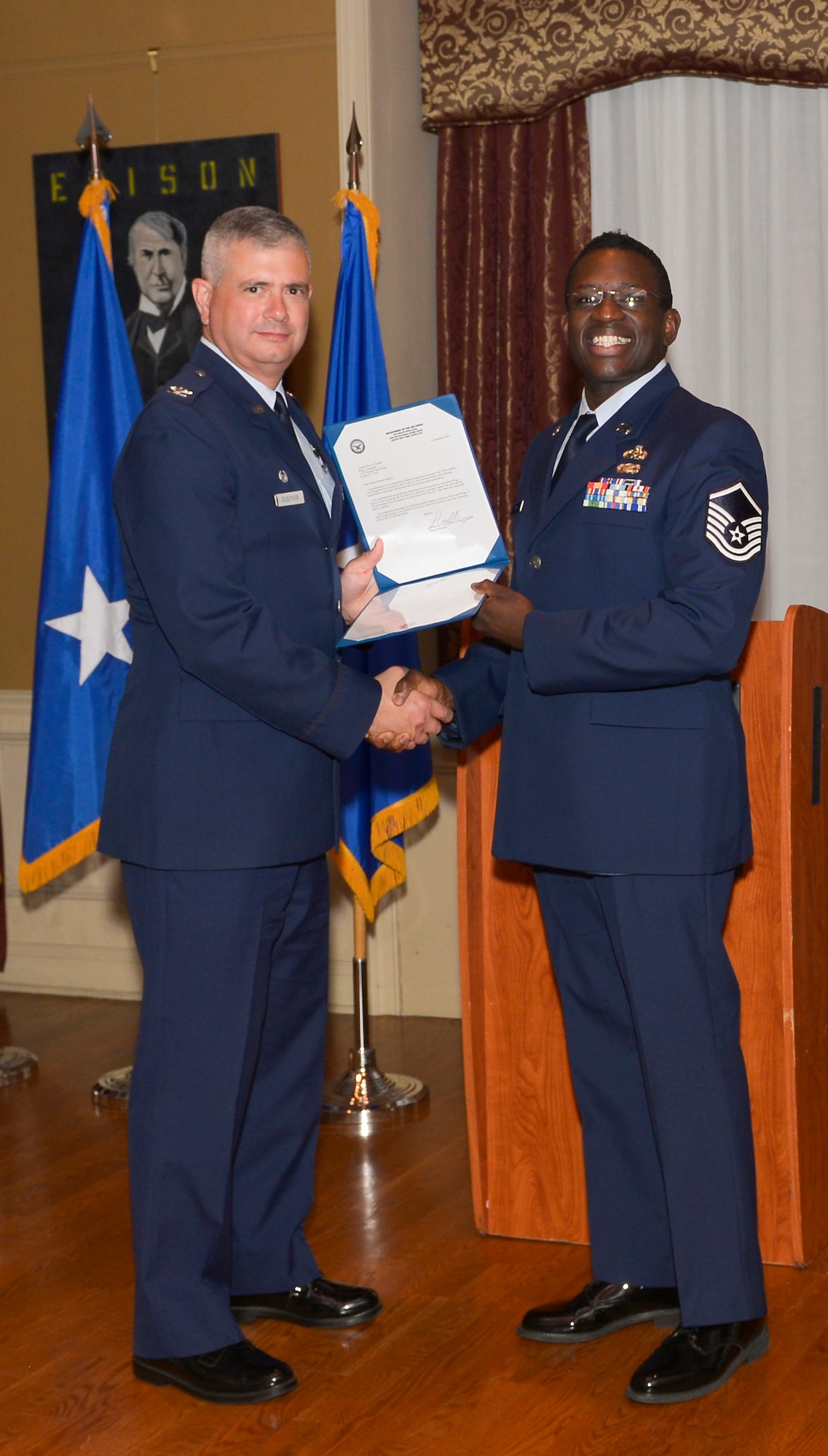 Col. Shawn Clouthier, 109th Airlift Wing commander, presents Master Sgt. David Ricks with the Certificate of Induction during a ceremony Sept. 25, 2014 at Schenectady County Community College, Schenectady, New York. The 109th AW Senior Noncommissioned Officer Induction Ceremony is an annual event held to recognize Airmen who were recently promoted to the rank of master sergeant. Ricks is assigned to the 109th Maintenance Group at Stratton Air National Guard Base. (U.S. Air National Guard photo by Master Sgt. William Gizara/Released)