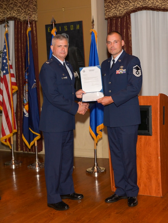 Col. Shawn Clouthier, 109th Airlift Wing commander, presents Master Sgt.Jeremy Muller with the Certificate of Induction during a ceremony Sept. 25, 2014 at Schenectady County Community College, Schenectady, New York. The 109th AW Senior Noncommissioned Officer Induction Ceremony is an annual event held to recognize Airmen who were recently promoted to the rank of master sergeant. Muller is assigned to the 109th Logistics Readiness Squadron at Stratton Air National Guard Base. (U.S. Air National Guard photo by Master Sgt. William Gizara/Released)