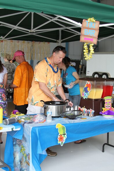 Loadmaster, Senior Master Sgt. Joe A. Nichols, 356th Airlift Squadron, Joint Base San Antonio-Lackland, Texas prepares to put finishing touches on the Hawaii booth, Sept. 19, 2014 during the Folklife Festival. The 433rd Airlift Wing’s 2014 Folklife Festival was held to celebrate the various heritages that make-up the cultural diversity of the Alamo Wing. (U.S. Air Force photo/Staff Sgt. Cassie Segreti)