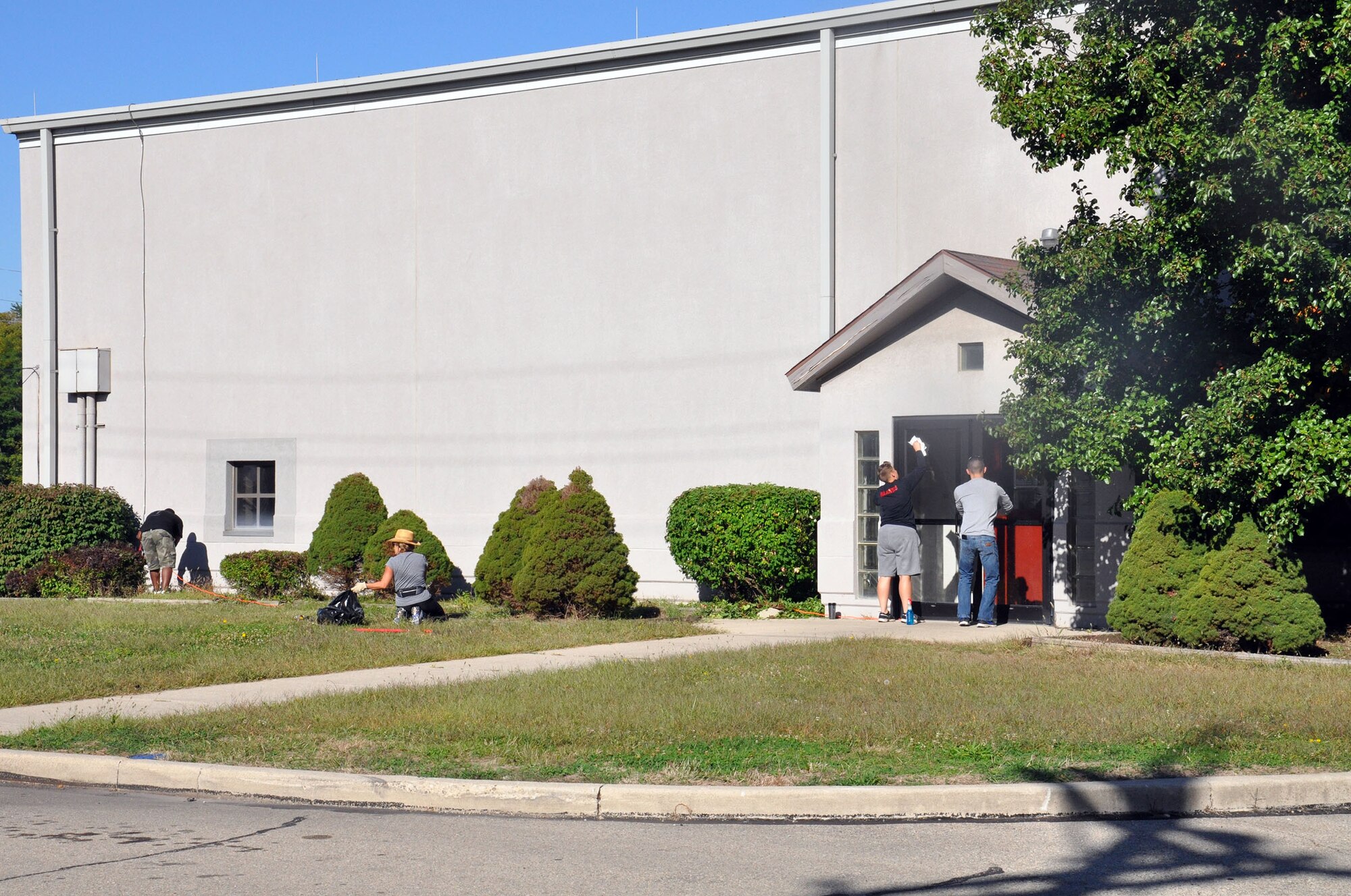 WRIGHT-PATTERSON AIR FORCE BASE, Ohio – Members of the 445th Mission Support Group wash windows to the entrance of Building 4014 as well as weed and trim during the 445th Airlift Wing Weed and Seed Morale Day Sept. 26, 2014. The event was held to beautify the surrounding area of the wing and enhance esprit de corps. Airmen from the wing picked up trash, weeded, mowed and trimmed around the various buildings. The volunteers enjoyed doing something different and enjoyed working in teams to better their facilities and work areas (U.S. Air Force photo/Stacy Vaughn)