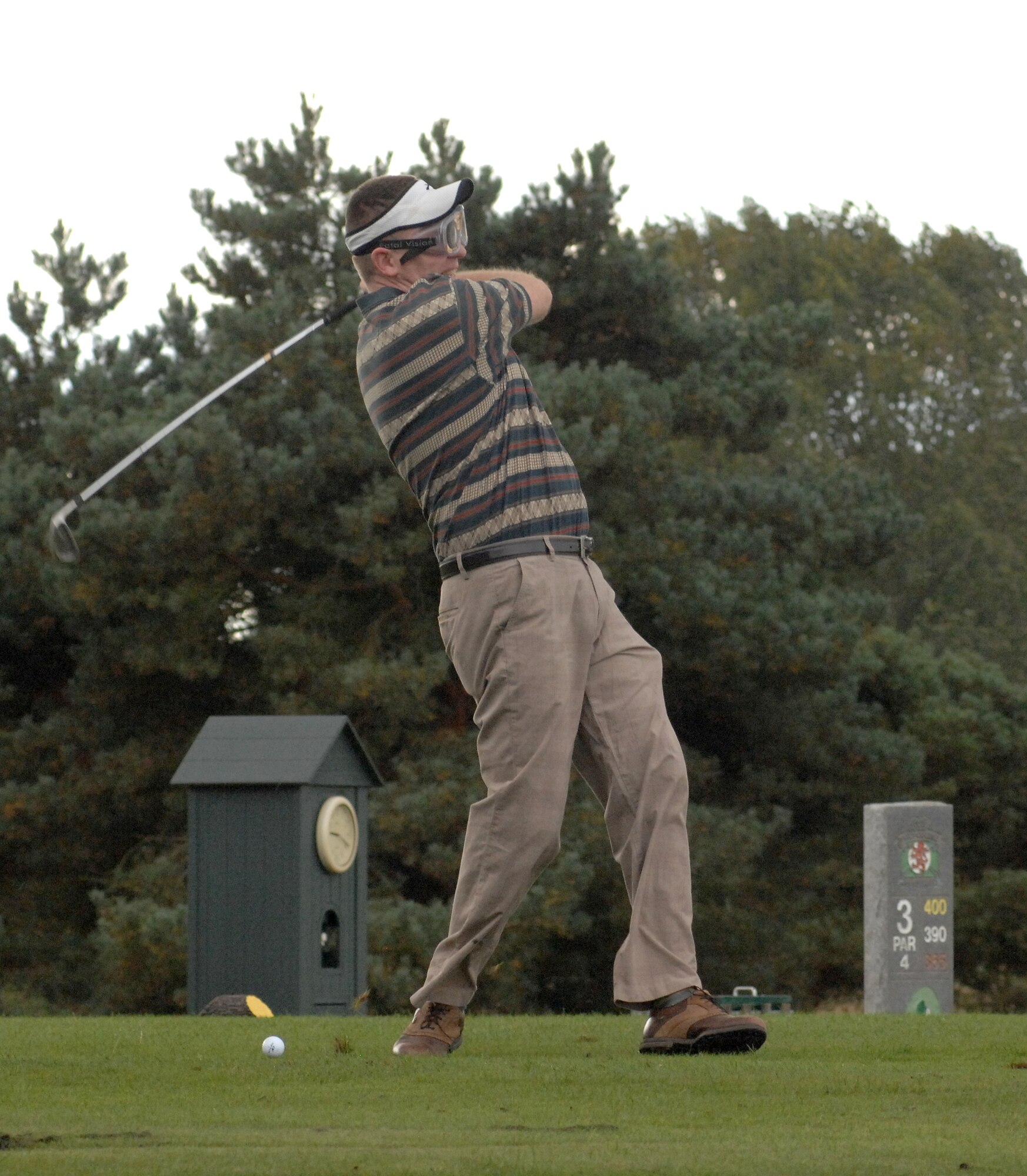 U.S. Air Force Senior Master Sgt. Chad Bickley, 100th Security Forces Squadron security forces manager from Castlewood, Va., swings and misses the ball while wearing beer goggles on the third hole at the Chiefs vs. Eagles Golf Tournament Sept. 24, 2014, at the Breckland Pines Golf Club on RAF Lakenheath, England. Golfers had to do a variety of tasks at different parts of the golf course ranging from 20 push-ups before hitting their drive on the second hole to putting with a hockey stick on the fourth green. (U.S. Air Force photo/Gary Rogers/Released)