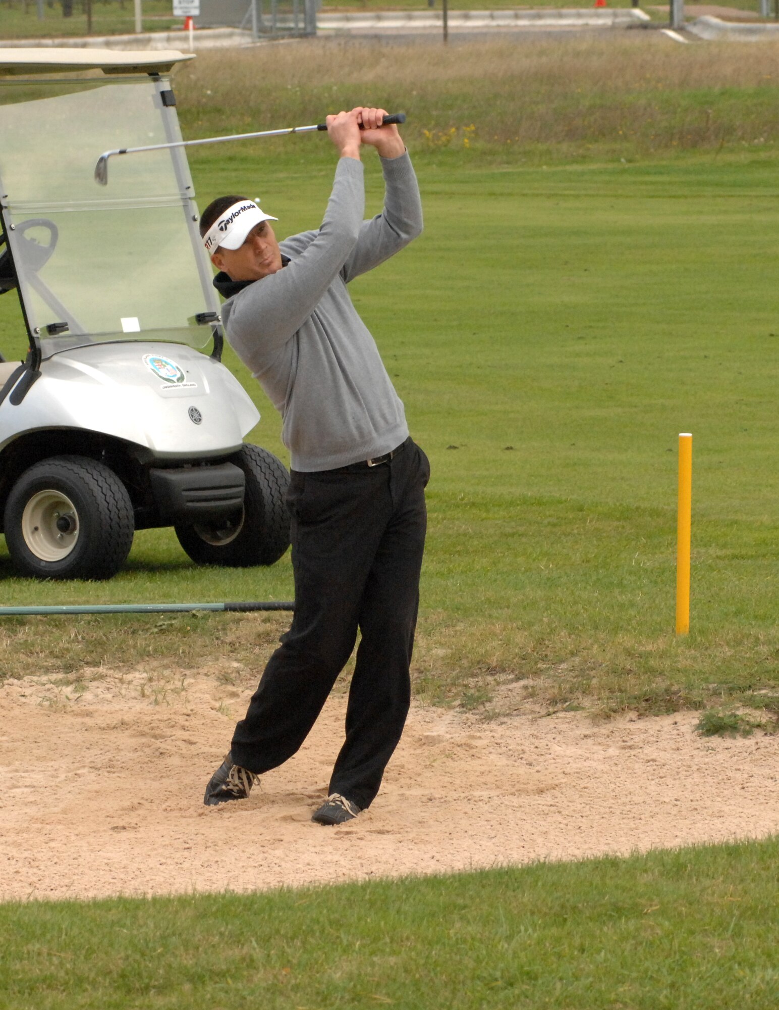 U.S. Air Force Chief Master Sgt. Tracy Jones, 100th Air Refueling Wing command chief, plays a shot out of the sand on the fifth hole at the Chiefs vs. Eagles Golf Tournament Sept. 24, 2014, at the Breckland Pines Golf Club on RAF Lakenheath, England. The golfers had to start the hole in the sand trap, which was one of many shots they had to play differently as part of the golf competition. (U.S. Air Force photo/Gary Rogers/Released)