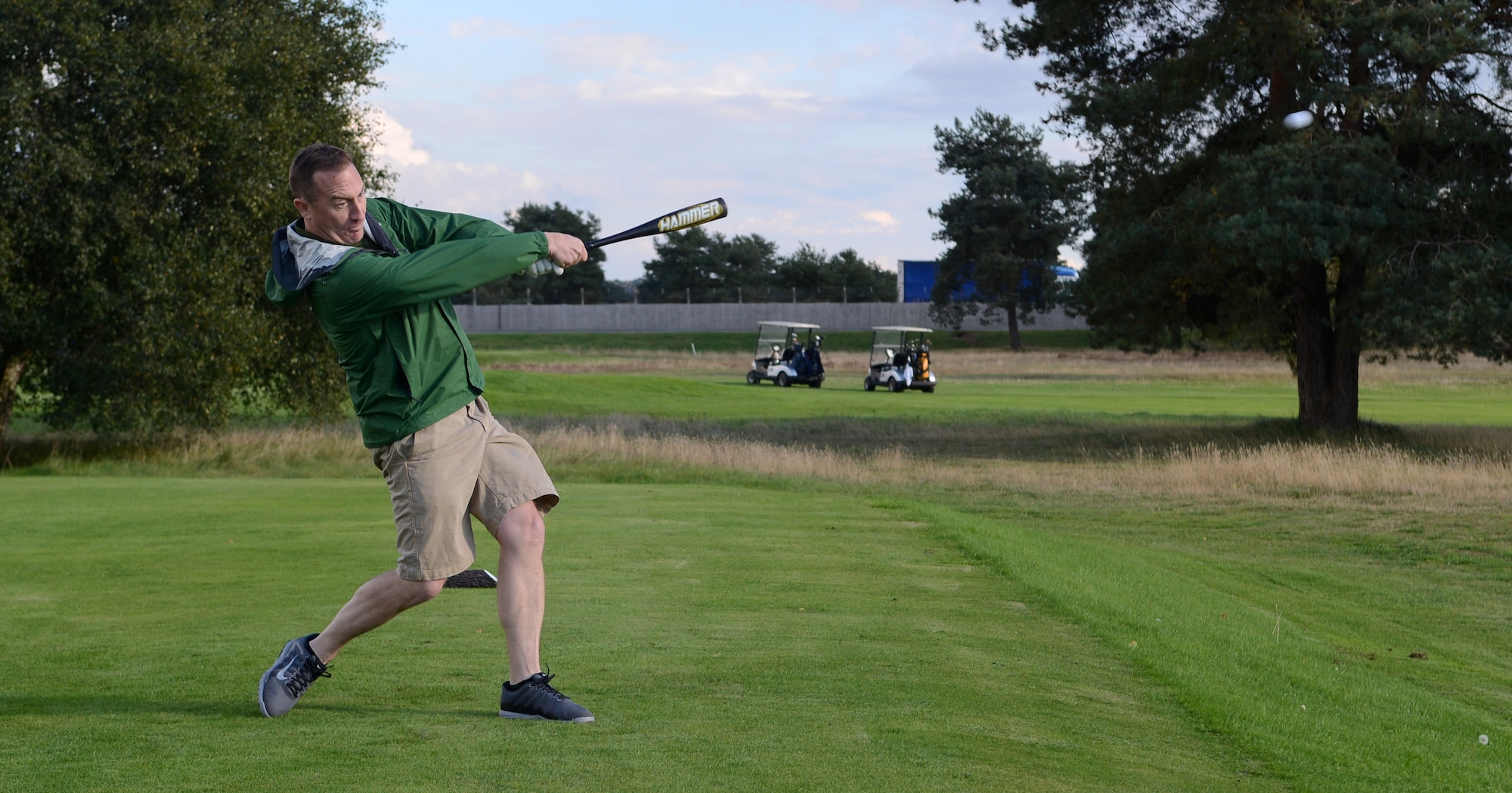 U.S. Air Force Lt. Col. Nathan Green, 352nd Special Operations Group commander, hits a golf ball with a baseball bat during the Chiefs vs. Eagles golf tournament Sept. 24, 2014, at the Breckland Pines Golf Club on RAF Lakenheath, England. The challenge of this hole was to drive the ball as far as possible using a bat instead of a club. (U.S. Air Force photo/Airman 1st Class Dillon Johnston/Released)