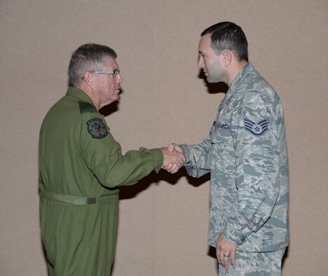 Lieutenant-General Alain Parent, North American Aerospace Defense Command deputy commander, recognizes Staff Sgt. Ian Geroux, a member of the 601st Air and Space Operations Center Combat Operations Division, with a coin during a recent visit to the 601st AOC at Tyndall Air Force Base, Fla. Sept. 24, 2014. Parent's visit included talks with Continental U.S. NORAD Region and AOC leadership as well as a stop by the AOC's operation floor to speak with members of the AOC. (Air National Guard photo by Lt. Col. Steve Burke/Released)