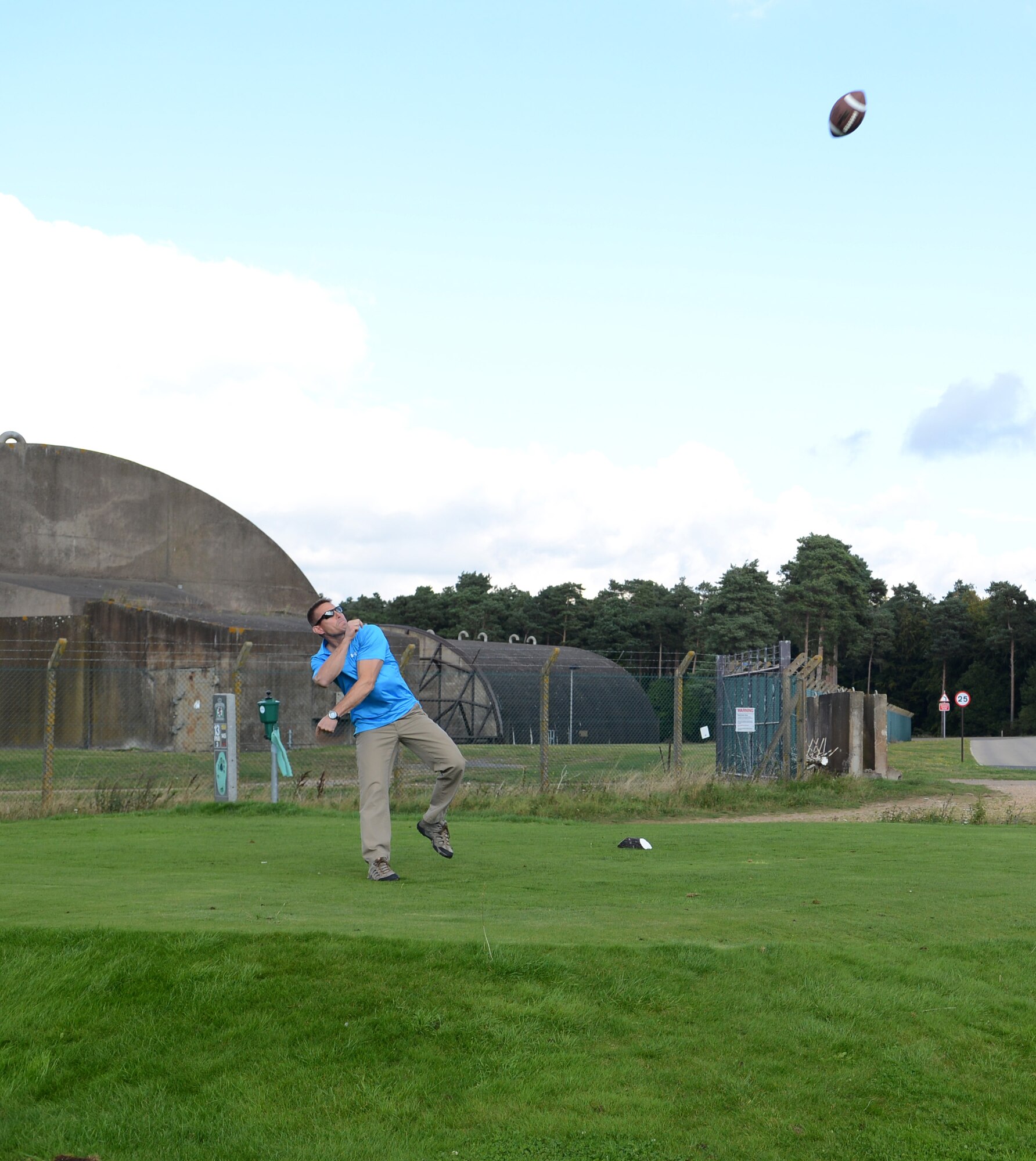 U.S. Air Force Chief Master Sgt. Floilan England, 352nd Special Operations Group chief enlisted manager from Navarre, Fla., throws a football from the tee box during the Chiefs vs. Eagles golf tournament Sept. 24, 2014, at the Breckland Pines Golf Club on RAF Lakenheath, England. The hole required each golfer to throw a football instead of teeing off for an added challenge. (U.S. Air Force photo/Airman 1st Class Dillon Johnston/Released) 