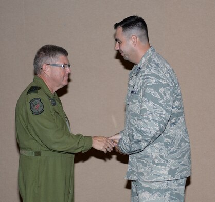 Lieutenant-General Alain Parent, North American Aerospace Defense Command deputy commander, recognizes Capt. Jared Scott, 601st Air and Space Operations Center public affairs officer, with a coin during a recent visit to the 601st AOC at Tyndall Air Force Base, Fla. Sept. 24, 2014. Parent's visit included talks with Continental U.S. NORAD Region and AOC leadership as well as a stop by the AOC's operation floor to speak with members of the AOC. (Air National Guard photo by Lt. Col. Steve Burke/Released)