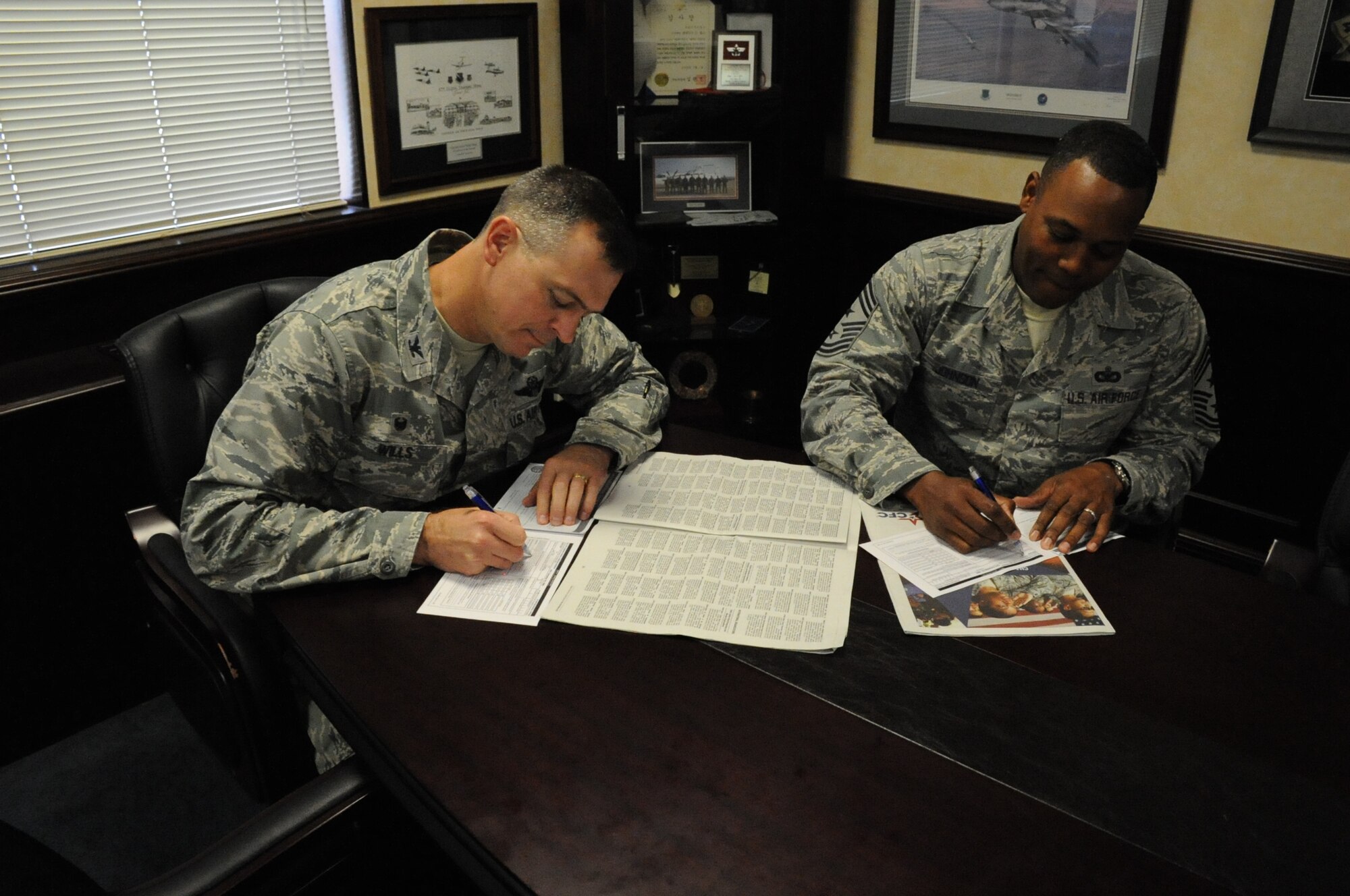 Col. Craig Wills, 39th Air Base Wing commander, and Chief Master Sgt. Anthony Johnson, 39th ABW command chief, sign Combined Federal Campaign-Overseas donation forms Sept. 24, 2014, Incilik Air Base, Turkey. The CFC-Overseas campaign is from Sept. 8 - Nov. 7, 2014. (U.S. Air Force photo by Airman Cory W. Bush/Released)