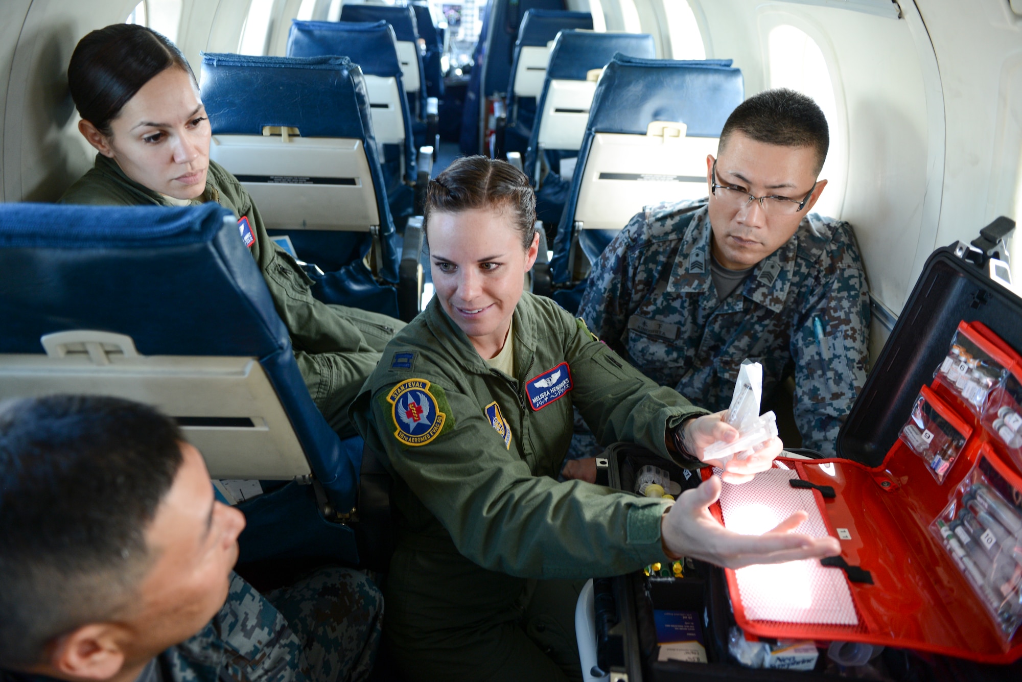U.S. Air Force Capt. Melissa Hendricks, 18th Aeromedical Evacuation Squadron flight commander, informs a group of Japan Air Self-Defense Force members about the contents inside a medevac container at Kadena Air Base, Japan, Sept. 24, 2014. Hendricks, assisted by the 459th Airlift Squadron, highlighted the C-12 medevac capabilities to the JASDF members. (U.S. Air Force photo by Staff Sgt. Cody H. Ramirez/Released) 
