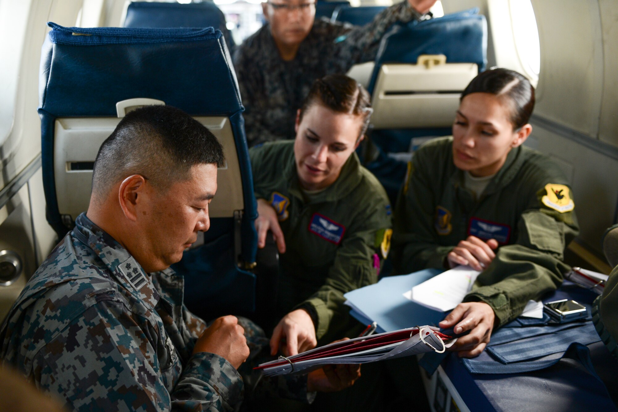 Japan Air Self-Defense Force Col. Tetsuya Tsujimoto discusses medical evacuation procedures with U.S. Air Force Capt. Melissa Hendricks while observing the U.S. crew perform medevac training over Kadena Air Base, Japan, Sept. 24, 2014. Tsujimoto and his team flew with the 459th Airlift Squadron to Kadena to observe their C-12 medevac capabilities. (U.S. Air Force photo Cody H. Ramirez/Released)