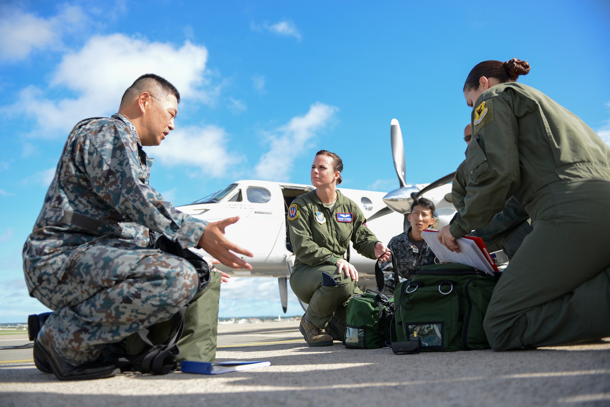 Japan Air Self-Defense Force Col. Tetsuya Tsujimoto, commander of JASDF Aero-medical Evacuation Squadron, clarifies questions with Capt. Melissa Hendricks, 18th Aeromedical Evacuation Squadron flight commander, before observing medical evacuation training on a C-12 at Kadena Air Base, Japan, Sept. 24, 2014. Tsujimoto was one of three JASDF members who flew to Kadena with members of the 459th Airlift Squadron to witness C-12 medevac capabilities. (U.S. Air Force photo by Staff Sgt. Cody H. Ramirez/Released) 