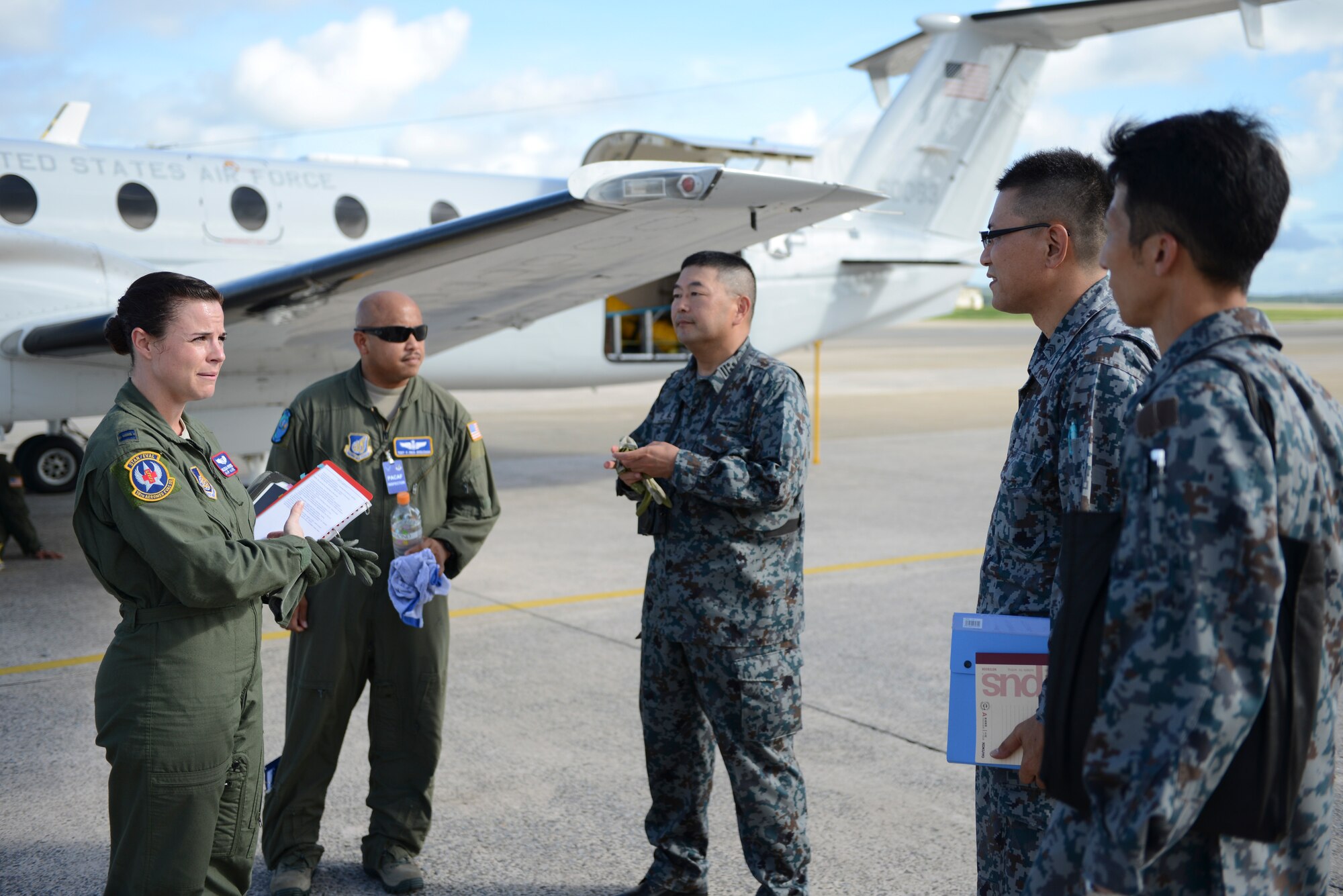 Capt. Melissa Hendricks (Left), 18th Aeromedical Evacuation Squadron flight commander, explains the medical evacuation training plan to Japan Air Self-Defense members before taking off at Kadena Air Base, Japan, Sept. 24, 2014. Hendricks was one of four 18 AES members who assisted in highlighting the C-12 medevac capabilities to the JASDF members. (U.S. Air Force photo by Staff Sgt. Cody H. Ramirez/Released)