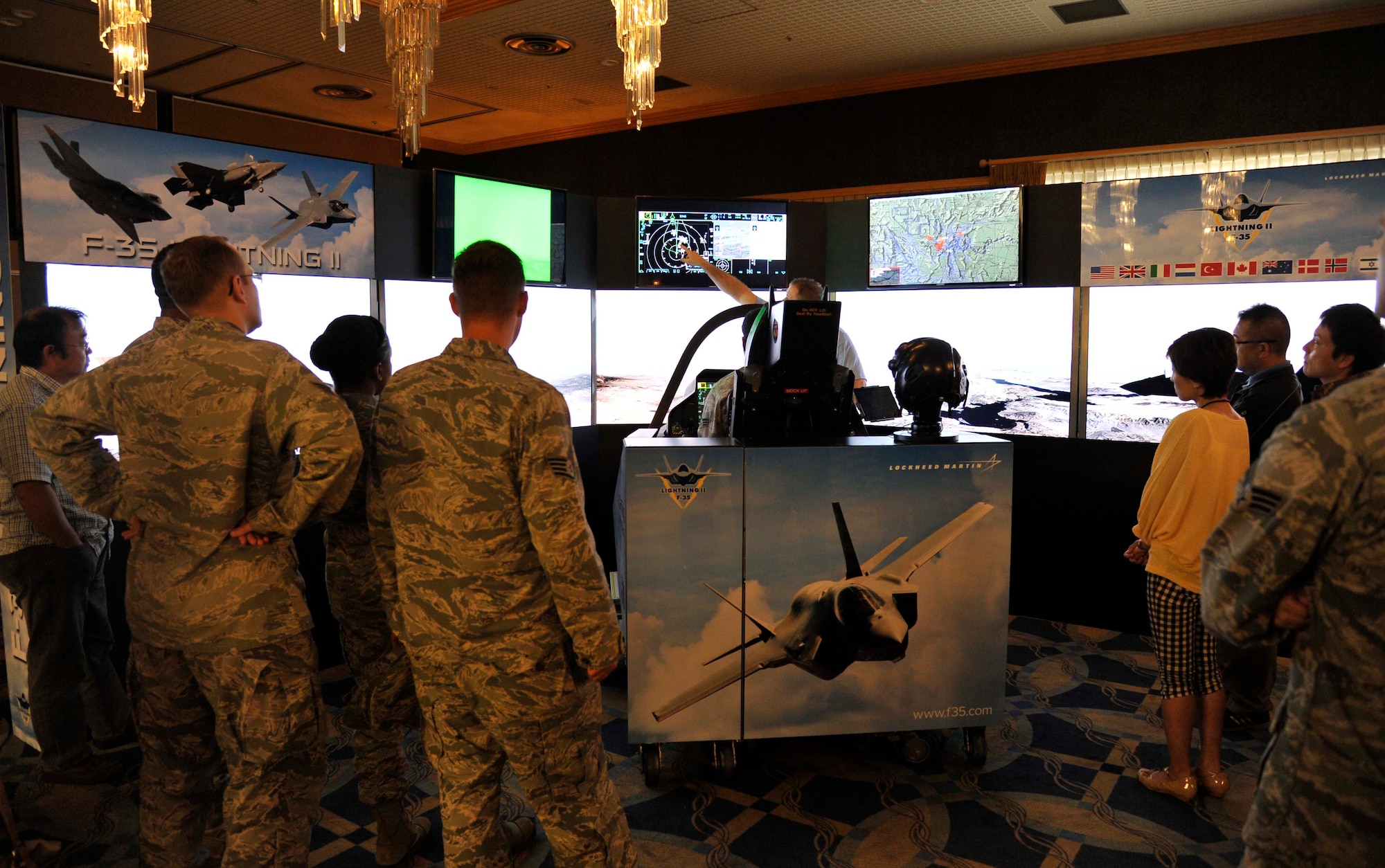 A group of Airmen and Japanese personnel observe a demonstration of the F-35 Lightning II’s flight capabilities at Misawa Air Base, Japan, Sept. 25, 2014. The simulation offered numerous scenarios for aspiring pilots to experience, exhibiting the F-35’s ability to perform various missions simultaneously while in the field. (U.S. Air Force photo by Airman 1st Class Patrick S. Ciccarone/Released) 