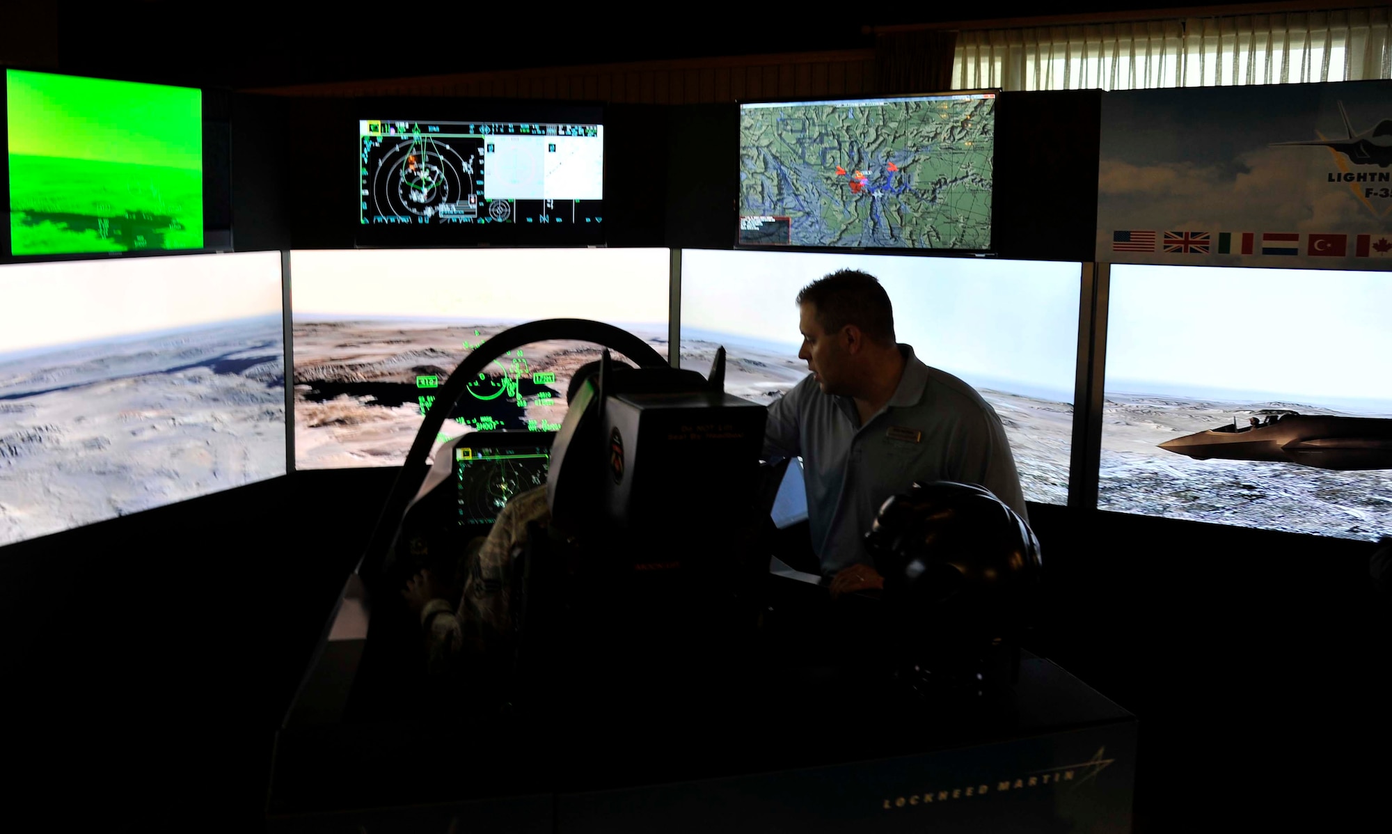 An F-35 Lightning II demonstration team member explains the aircraft’s cockpit controls to an Airman at Misawa Air Base, Japan, Sept. 25, 2014. The demonstration was held for personnel on base and included a five minute simulation of piloting the multi-role war fighter. (U.S. Air Force photo by Airman 1st Class Patrick S. Ciccarone/Released)