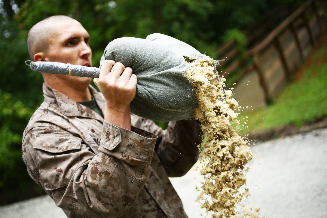 Marine Corps Cpl. Patrick D. Whitney empties a sand bag during a martial arts instructor course on Marine Corps Air Station Cherry Point, N.C., Sept. 24, 2014. Whitney is an ordnance technician assigned to Marine Attack Training Squadron 203.