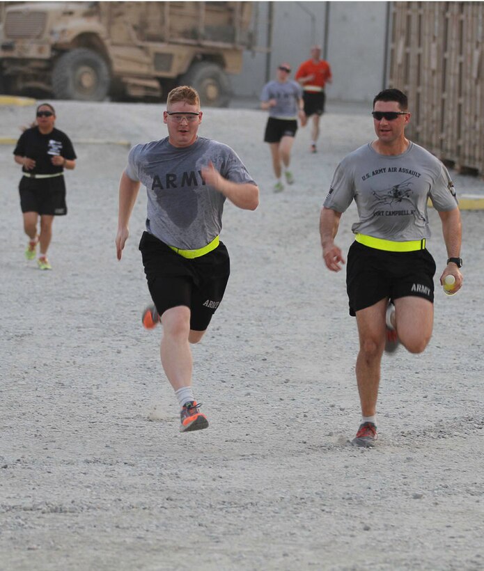 U.S. Army Capt. Christopher Fradin, right, encourages a soldier to run ...