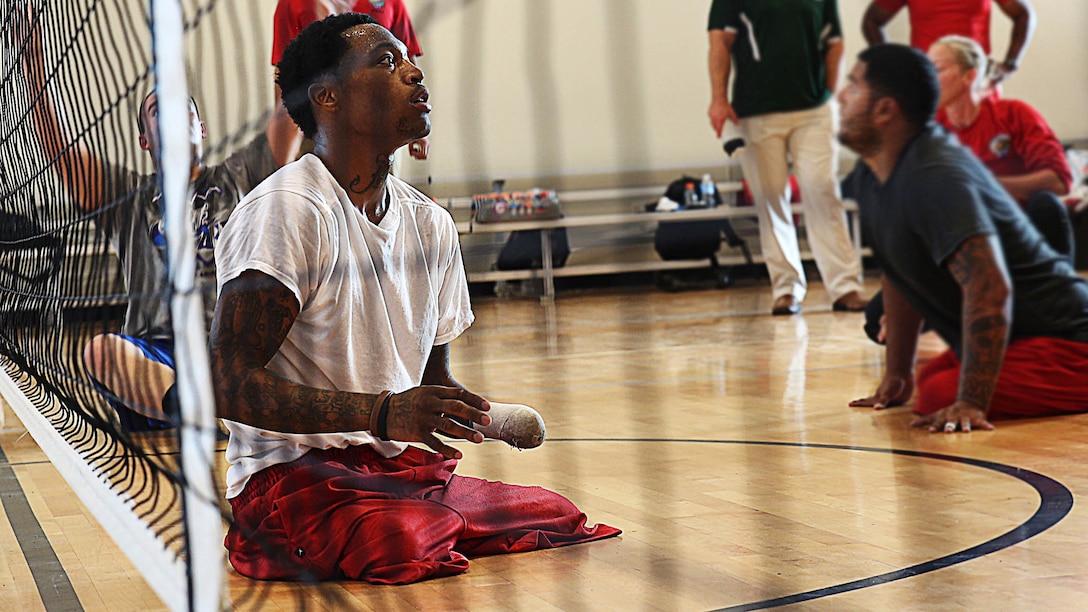 Sgt. Anthony McDaniel Jr. from Pascagoula, Mississippi, plays front and center during sitting volleyball practice for the Marine team, Sept. 26, in preparation for the 2014 Warrior Games. The Marine team has been training since September 15 in order to build team cohesion and acclimate to the above 6,000 feet altitude of Colorado Springs. The Marine team is comprised of both active duty and veteran wounded, ill and injured Marines who are attached to or supported by the Wounded Warrior Regiment, the official unit of the Marine Corps charged with providing comprehensive non-medical recovery care to wounded, ill and injured Marines. The Warrior Games are a Paralympic-style competition for more than 200 wounded, ill and injured service members and are taking place Sept. 28 to Oct. 4 at the Olympic Training Center in Colorado Springs, Colorado. Follow the Marine team's progress at www.facebook.com/wwr.usmc.