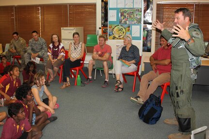 District of Columbia Air National Guard F-16 pilot Lt. Col. Eric Haagenson explains to students how his helmet and flight equipment help him survive and fly a fighter aircraft, during a visit to McFarlane Primary School in Katherine, Australia, Sept. 17, 2014.