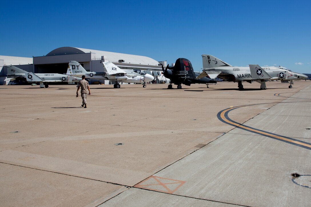 A Marine walks among aircraft from the Flying Leatherneck Aviation Museum on the flight line aboard Marine Corps Air Station Miramar, Calif., Sept. 25.  The air show will also feature vintage military aircraft called Warbirds as static displays. These aircraft are now operated by civilian organizations or individuals sometimes featured in air shows or at major events where aircraft are a large attraction.