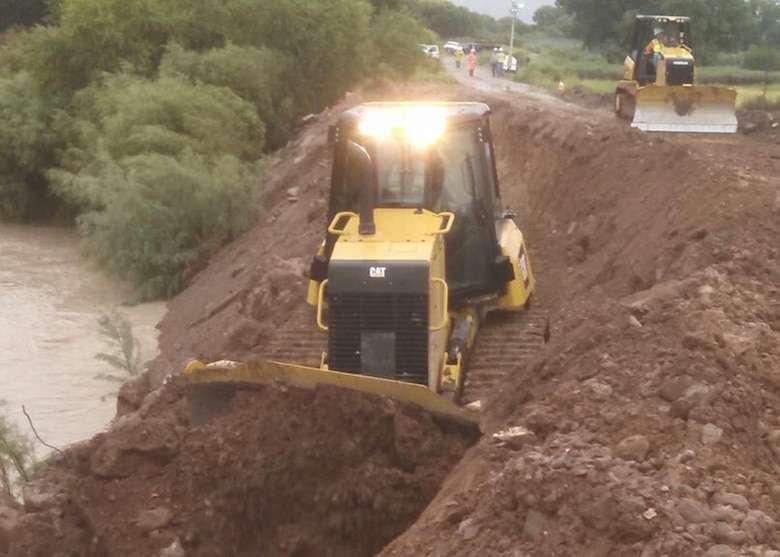 Workers with West Point Construction move material into place Sept. 18 as they continue emergency operations on the levee in Duncan, Ariz.  The company was the contractor for the U.S. Army Corps of Engineers Los Angeles District’s response team in response to a request from the State of Arizona’s Division of Emergency Management for assistance to help prevent a levee from breaching during a severe rainstorm which came as a result of Tropical Storm Odile. 