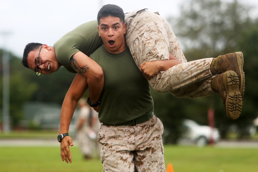 Lance Cpl. Rigoberto Rodriguez carries Lance Cpl. Davey Villalobos toward the finish line during the fireman carry event at Marine Corps Air Station Cherry Point, N.C., Sept. 26, 2014. The fireman’s carry was one of 11 events Marines and Sailors competed in during the 2014 Fall Field Meet between Headquarters and Headquarters Squadron and Marine Wing Headquarters Squadron 2. Rodriguez is a native of Concord, N.C., and Villalobos is a native of Reno, Nev. Both are administrative specialists with MWHS-2.