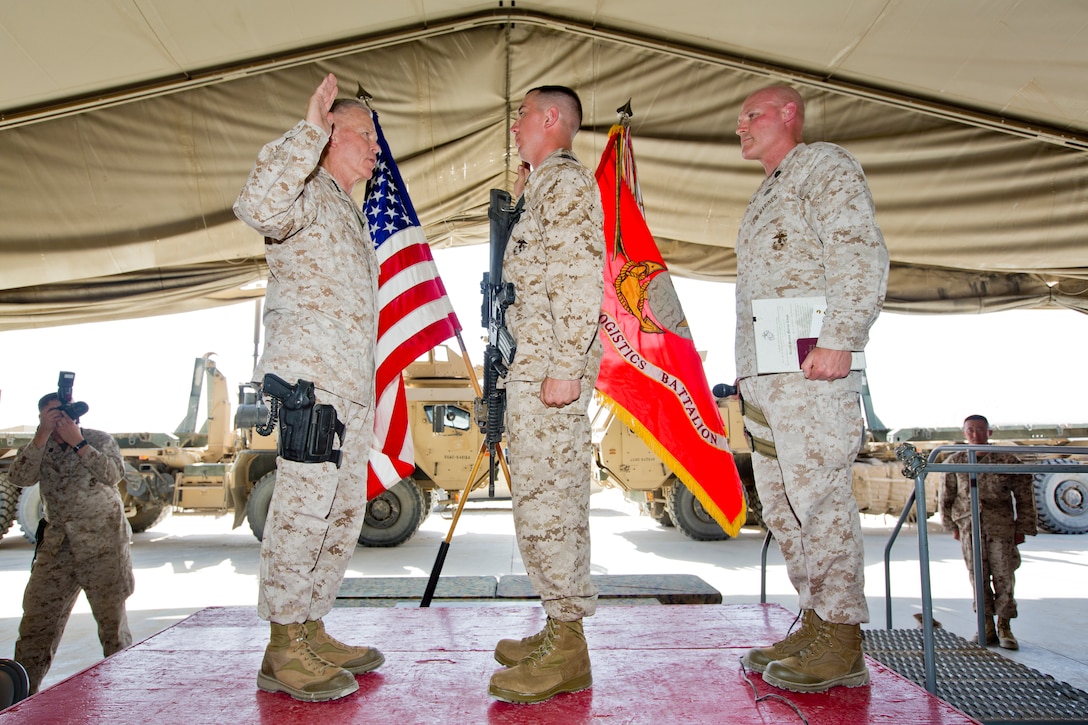 Commandant of the U.S. Marine Corps, Gen. James F. Amos, left, and Sergeant Major of the Marine Corps, Sgt. Maj. Micheal P. Barrett, right, meritoriously promote Cpl. William R. Gelroth with Combat Logistics Battalion 1, Combat Logistics Regiment 1, 1st Marine Logistics Group, during their visit at Camp Leatherneck, Helmand Province, Afghanistan, Sept. 6, 2014. Amos and Barrett visited Marines with Regional Command Southwest to thank and update them on current events within the Marine Corps. (U.S. Marine Corps photo by Sgt. Gabriela Garcia/Released)