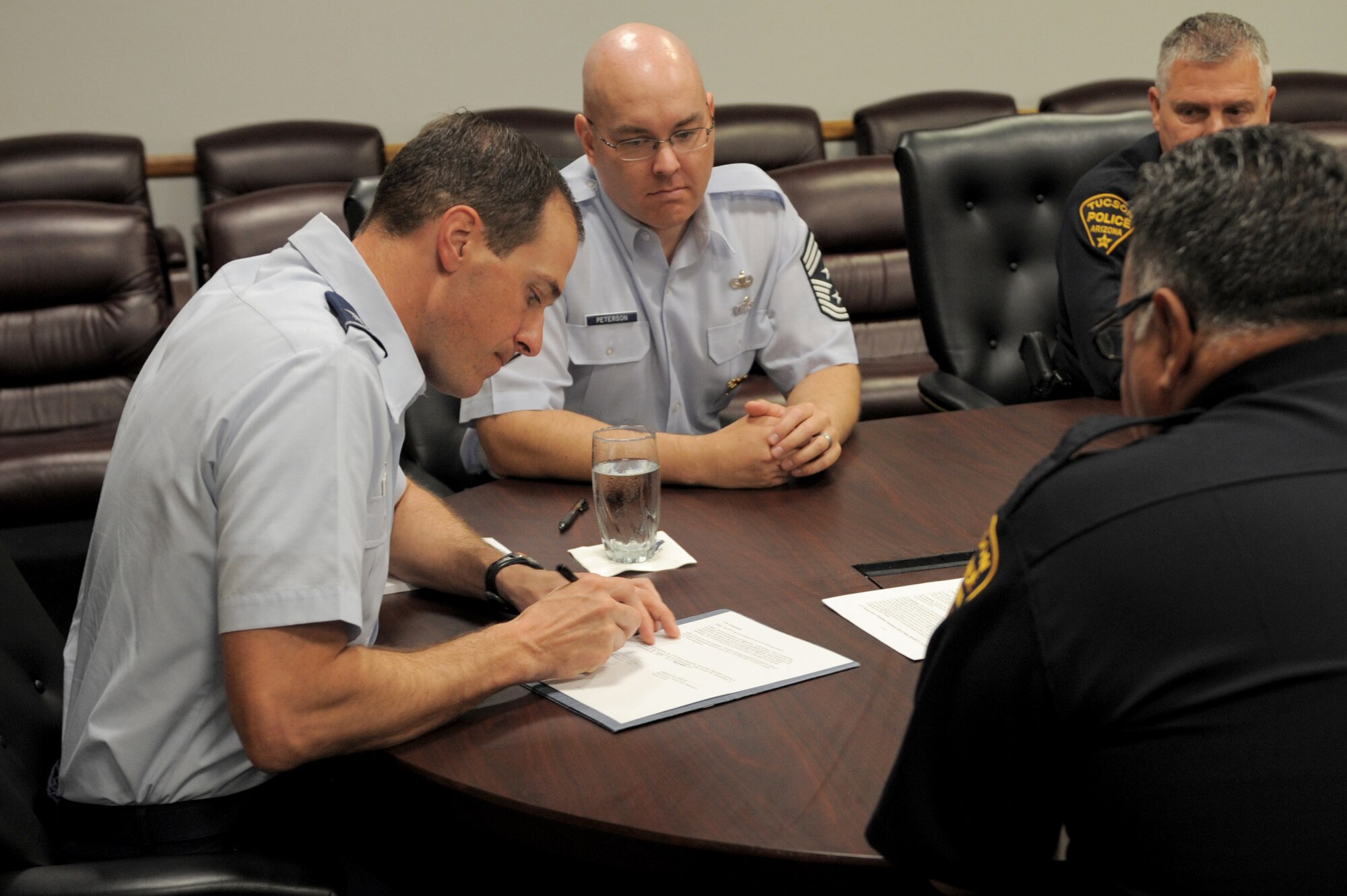 U.S. Air Force Col. James Meger, 355th Fighter Wing commander, signs the newest memorandum of understanding between the Tucson Police Department and 355th Security Forces Squadron at Davis-Monthan Air Force Base, Ariz., Sept. 29, 2014. The MOU outlines general responsibilities, communication, cooperation and procedures between the TPD and the 355th SFS to ensure coordinated operations between the agencies. (U.S. Air Force photo by Airman 1st Class Chris Drzazgowski/Released)