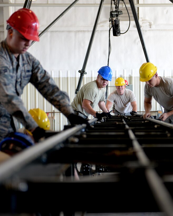 Airmen from the 28th Munitions Squadron assemble a munitions assembly conveyer during the Global Strike Challenge at Ellsworth Air Force Base, S.D., Sept. 26, 2014. Airmen participating in the event were carefully selected through their performances during weekly competitions over the last several months. (U.S. Air Force photo by Airman 1st Class Rebecca Imwalle/Released)