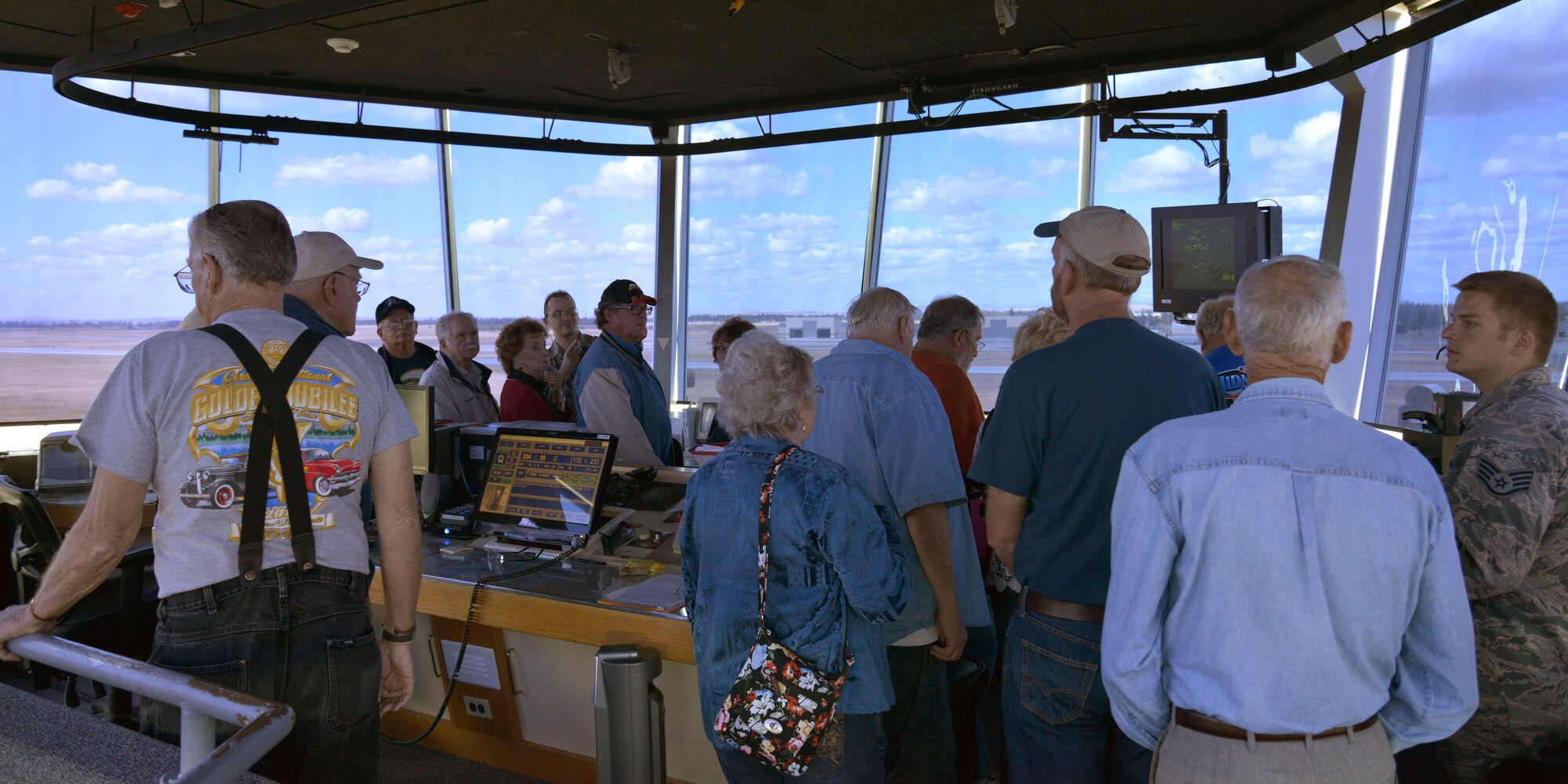 The Early Ford V-8 Club members look across Fairchild Air Force Base from inside the air traffic control tower during a base tour, Sept. 26, 2014. Fairchild hosted a tour that held stops at aerospace physiology, a KC-135 Stratotanker static display, the dining facility, Heritage Air Park, the wing headquarters and the air traffic control tower. (U.S. Air Force photo by Airman 1st Class Janelle Patiño/ Released)