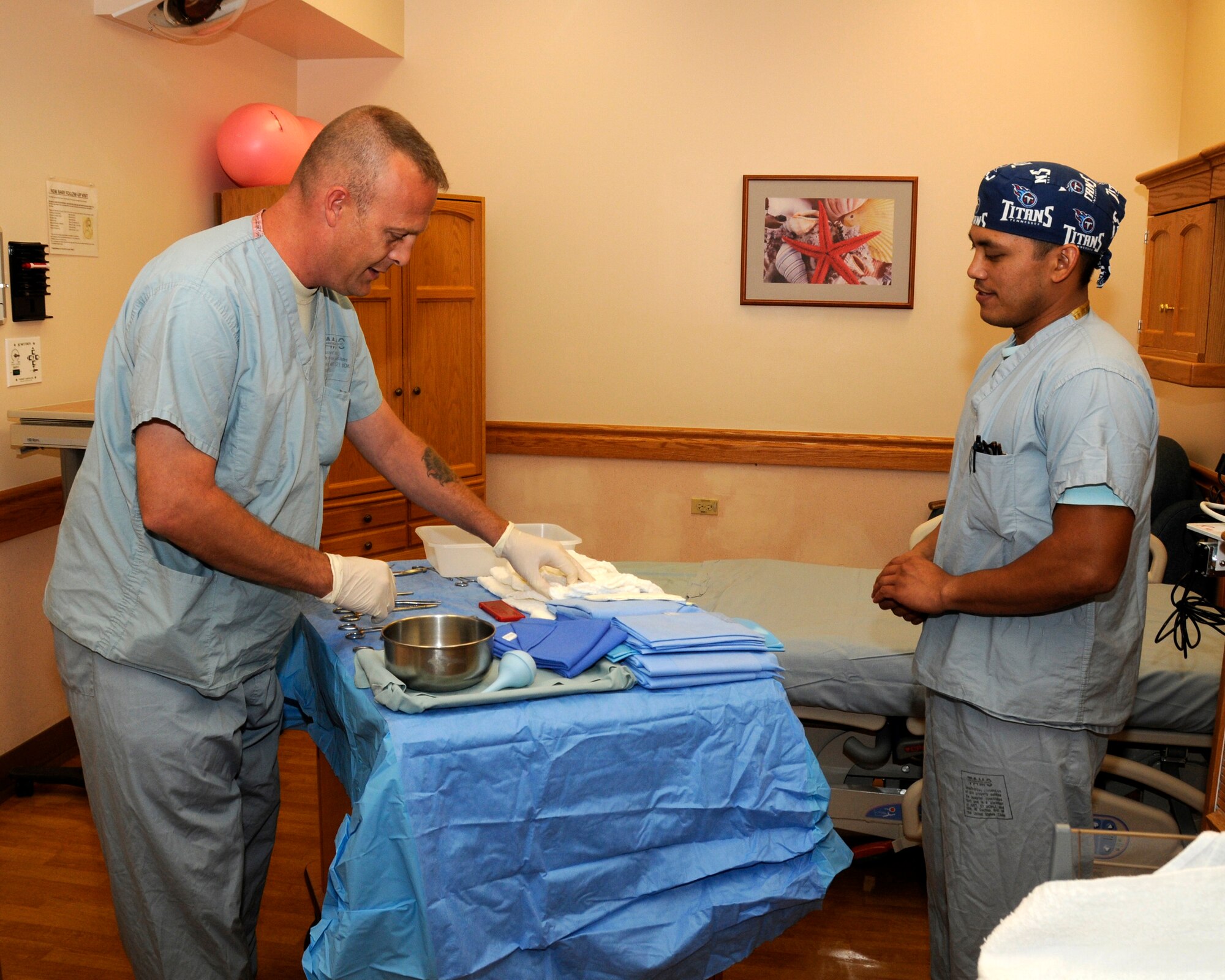 U.S. Air Force Tech. Sgt. Larry White (left), 182nd Medical Group, Peoria, Ill., works with Tripler Army Medical Center obstetrics scrub technician Christopher Mendoza to prepare the instruments used in a delivery room September 12, 2014. (U.S. Air National Guard photo by Tech. Sgt. Todd Pendleton) 