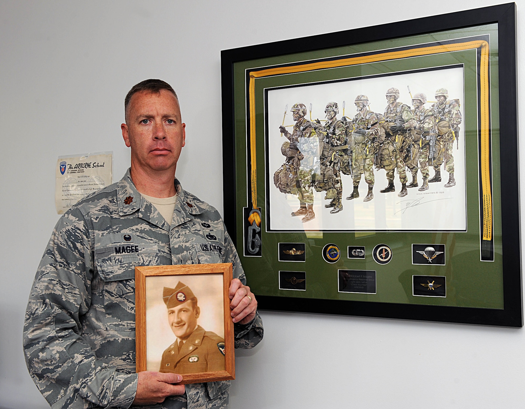 Maj. Robert Magee, 22nd Logistics Readiness Squadron commander, poses with a photo of his grandfather in front of his paratrooper mementos, Sept. 29, 2014, at McConnell Air Force Base, Kan. Magee is successfully bringing his grandfather’s legacy back to light in order to honor the sacrifice he made during the Korean War. (U.S. Air Force photo/Airman 1st Class David Bernal Del Agua)
