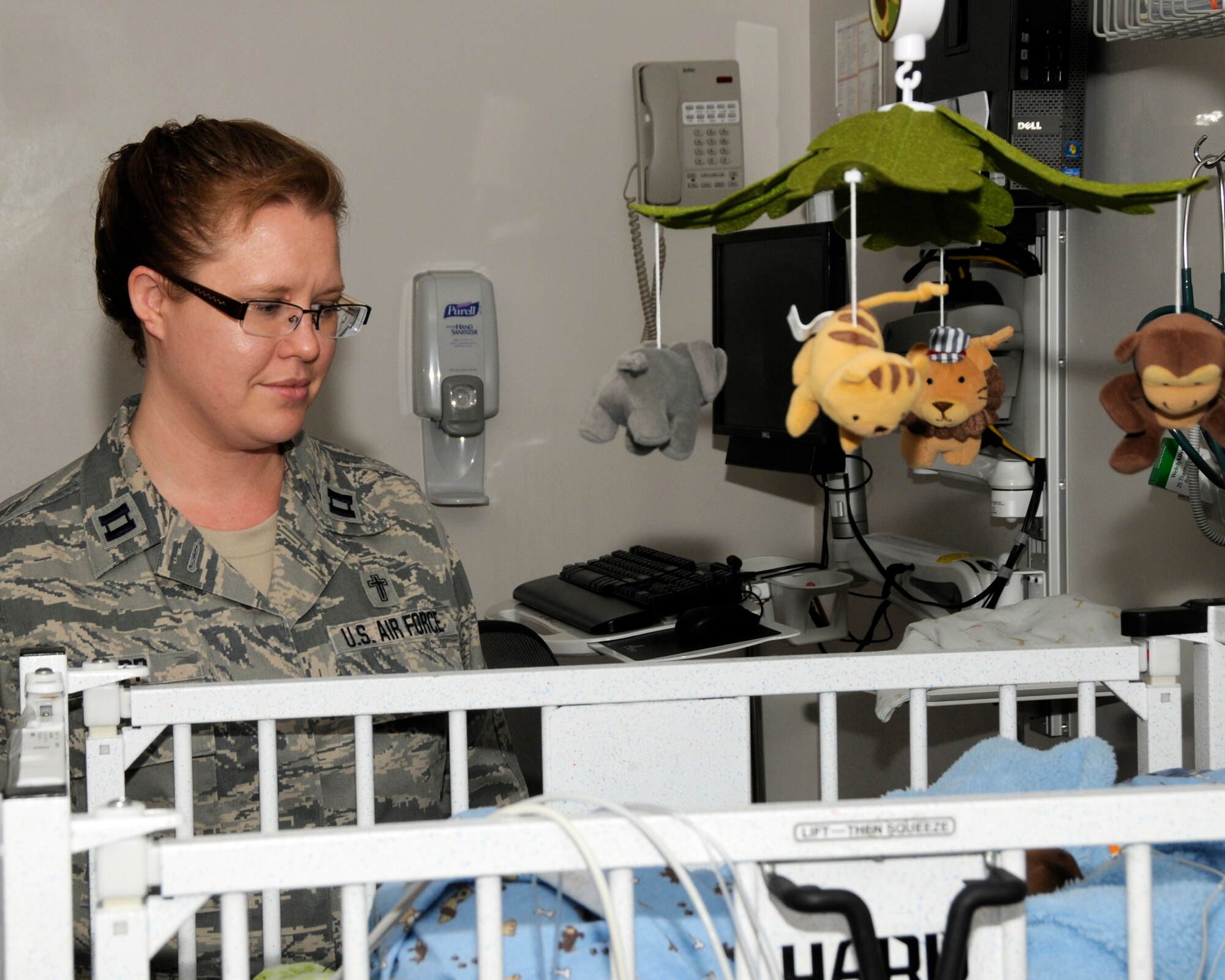U. S. Air Force Captain (Chaplain) Kristi Hopp, 182nd Airlift Wing, Peoria, Illinois, looks over a newborn in the neonatal unit of Tripler Army Medical Center, Hawaii, Sep. 12, 2014. Chaplain Hopp is performing her two weeks of Annual Training with the 182nd Medical Group's Overseas Annual Training (OSAT) held at Tripler. (U.S. Air National Guard photo by Tech. Sgt. Todd Pendleton) (Released)  