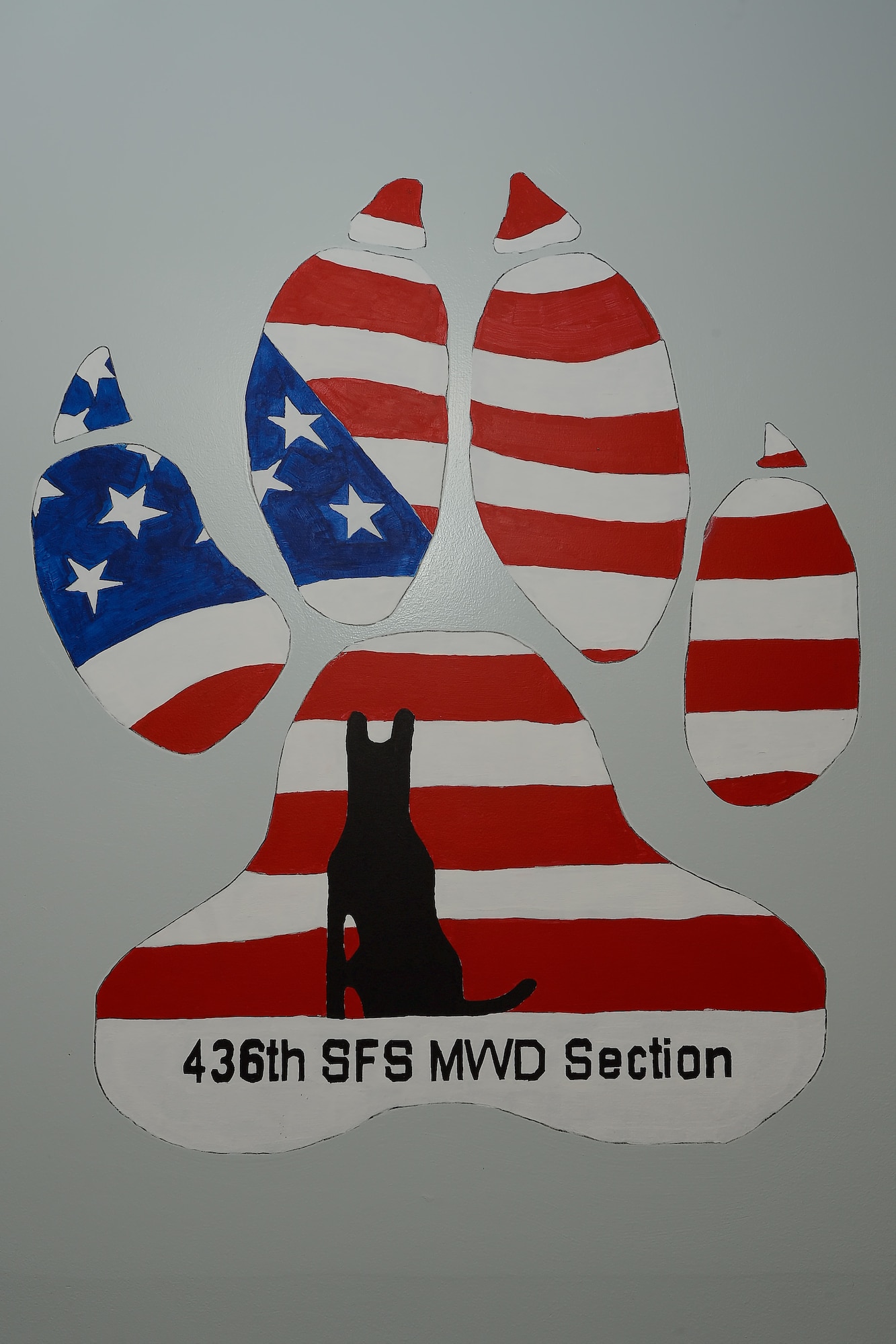 Elements of the American flag are shown painted across the outline of a canine paw-print adorning the wall inside the 436th Security Forces Squadron, military working dog section, Sept. 17, 2014, at Dover Air Force Base, Del. The large emblem can be seen from the personnel's duty desks and was hand-painted by a former dog handler. (U.S. Air Force photo/Greg L. Davis)