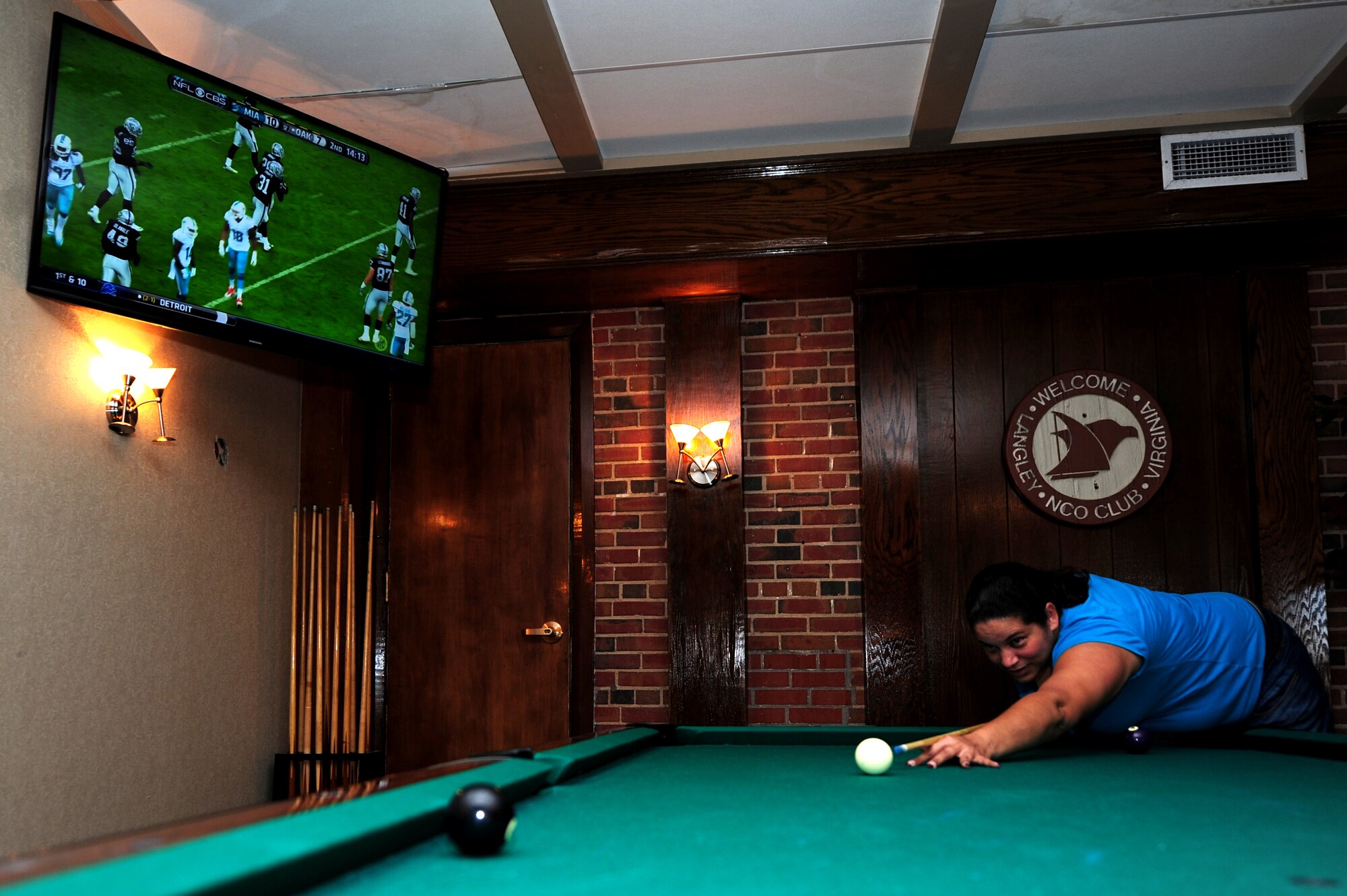 Tanya Pabon Rios, sister-in-law of Ann Pabon, 633rd Force Support Squadron Langley Club manager, plays pool at the Langley Club on Langley Air Force Base, Va., Sept. 29, 2014. In addition to viewing football on Sundays, club patrons can order drinks and food, and play pool. (U.S. Air Force photo by Airman 1st Class Areca T. Wilson/Released) 