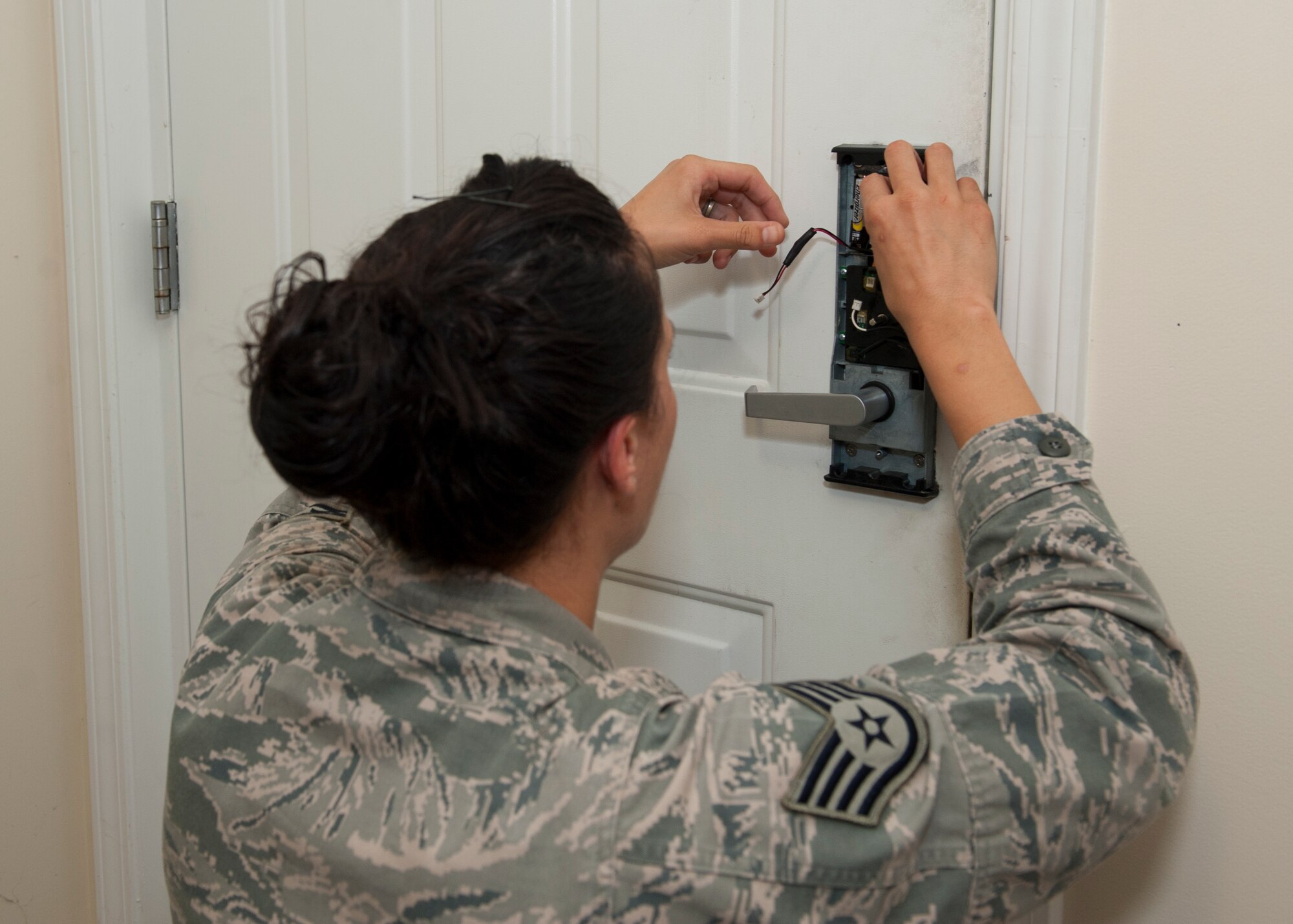 Staff Sgt. Britini Jennie, 436th Civil Engineer Squadron Airman dormitory leader, replaces the batteries in a dormitory resident’s lock Sept. 4, 2014, in building 414 on Dover Air Force Base, Del. There has been a 68 percent increase in the amount of dorm lockouts in 2014, compared to the previous year. (U.S. Air Force photo/Airman 1st Class Zachary Cacicia) 