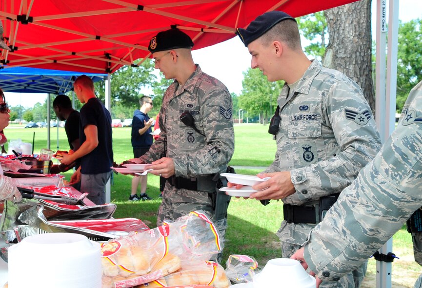 Members of the 4th Security Forces Squadron are treated to helpings of southern comfort food during a Dorm Dwellers Barbecue at Seymour Johnson Air Force Base, N.C., Sept. 27, 2014. (U.S. Air Force photo/Airman 1st Class Ashley J. Thum)