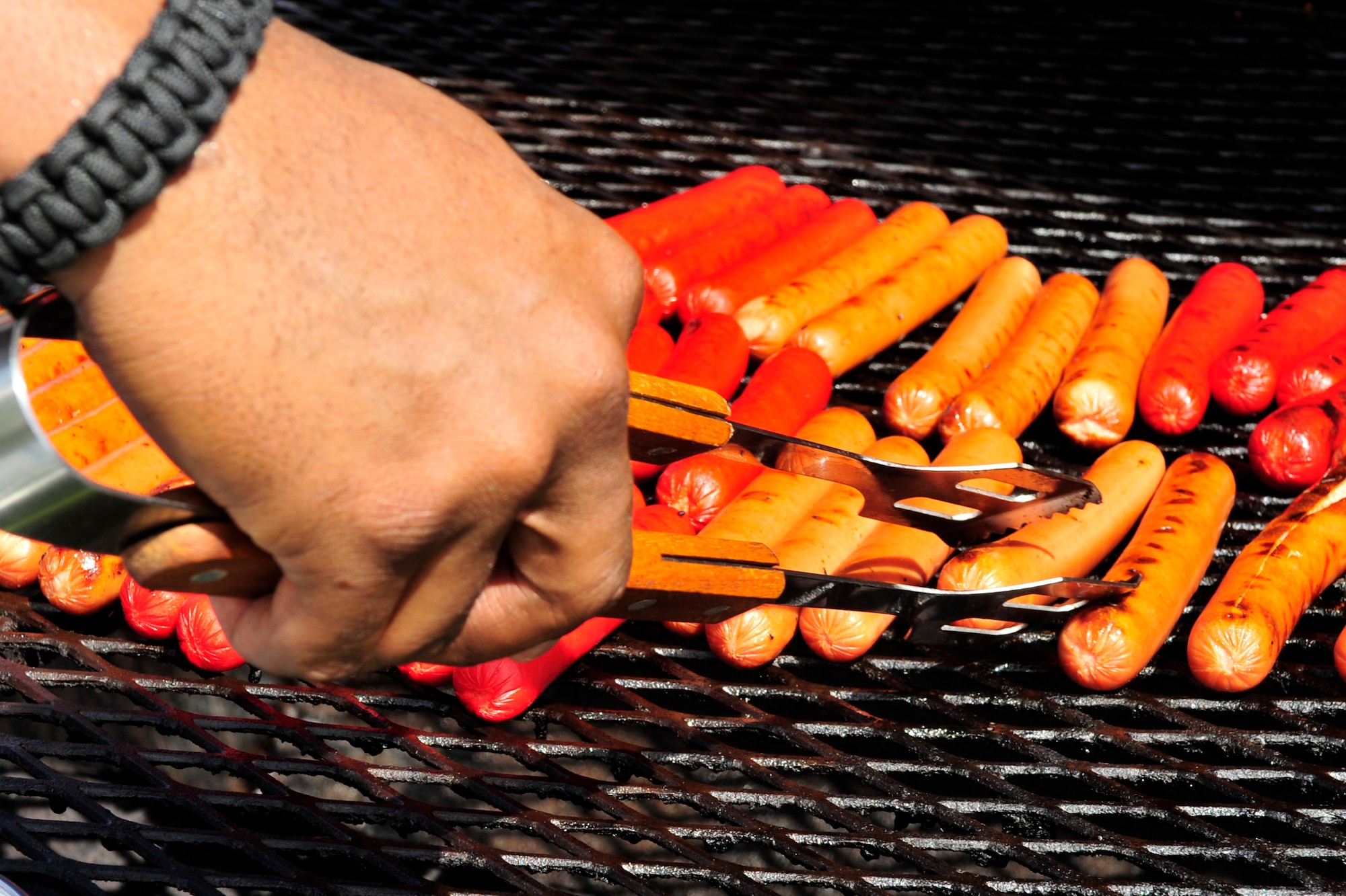 Tech. Sgt. Wayne Keys, 335th Fighter Squadron weapons technician, puts the finishing touches on hot dogs for a Dorm Dwellers Barbecue at Seymour Johnson Air Force Base, N.C., Sept. 27, 2014. Airmen living in the dorms were treated to a free lunch, and the Airmen’s Center was opened for pool, ping pong and other activities. (U.S. Air Force photo/Airman 1st Class Ashley J. Thum)