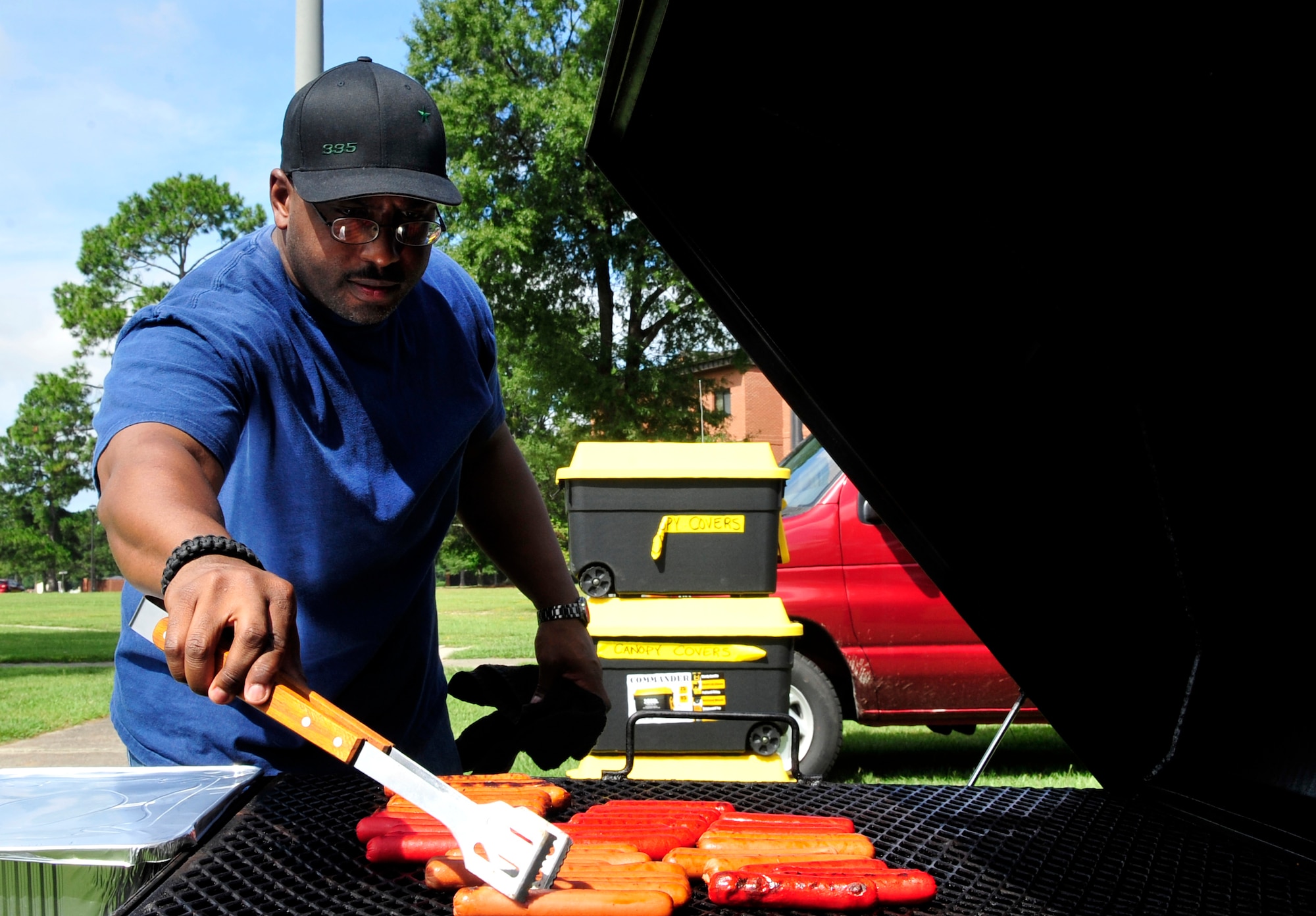 Tech. Sgt. Wayne Keys, 335th Fighter Squadron weapons technician, rotates hot dogs on the grill during a Dorm Dwellers Barbecue at Seymour Johnson Air Force Base, N.C., Sept. 27, 2014. Keys and other volunteers prepared hot dogs, hamburgers and desserts for the unaccompanied members of Team Seymour. (U.S. Air Force photo/Airman 1st Class Ashley J. Thum)