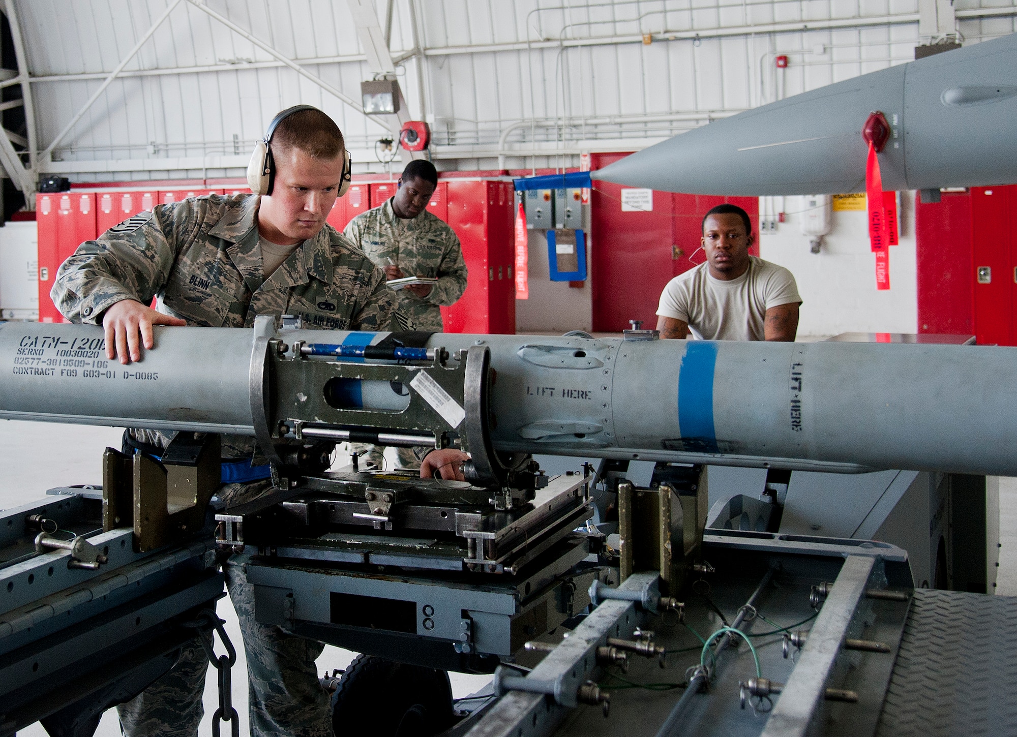 Staff Sgt. Mark Blinn, of the 96th Aircraft Maintenance Squadron Blue, secures an AIM-120 missile for loading onto the F-16 Fighting Falcon, during the 96th Maintenance Group’s quarterly weapons load crew competition Sept. 26 at Eglin Air Force Base, Fla. Blinn, Airmen 1st Class Frederick Guaren and Troy Carpenter made up the Blue team who won the competition. (U.S. Air Force photo/Chrissy Cuttita)