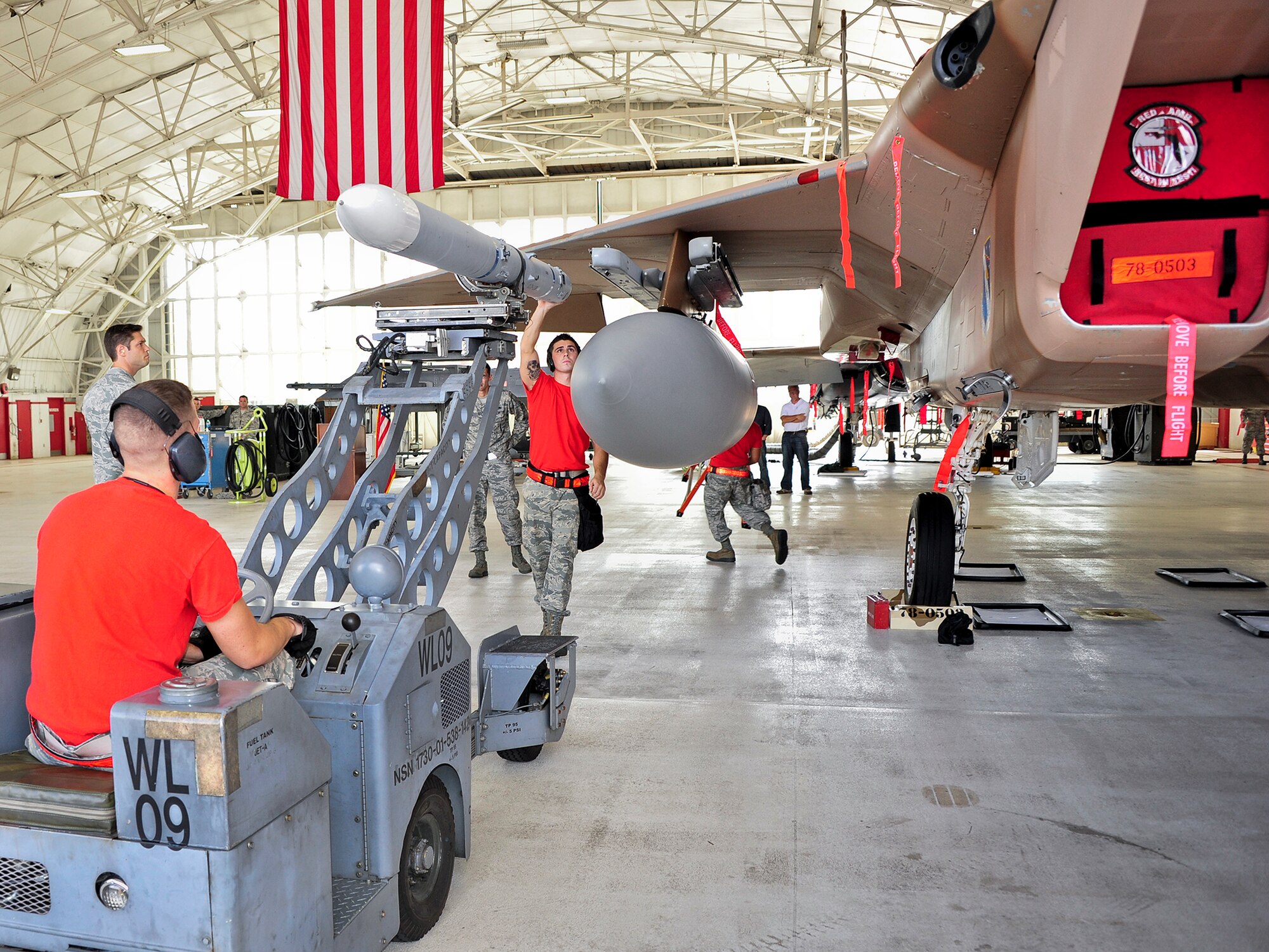 Staff Sgt Isaac Tolentino, Senior Airman Lance O’Rourke and Airman 1st Class Colin Reeder, of the 96th Aircraft Maintenance Squadron Red, position an AIM-120 missile for loading onto an F-15 Eagle, during the 96th Maintenance Group’s quarterly weapons load crew competition Sept. 26 at Eglin Air Force Base, Fla. (U.S. Air Force photo/Ilka Cole)