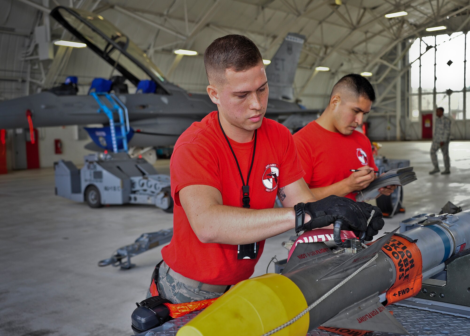 Senior Airmen Lance O’Rourke and Staff Sgt Isaac Tolentino, of the 96th Aircraft Maintenance Squadron Red, secures an umbilical on a AIM-9X for loading onto the F-15 Eagle while his team lead and inspectors look on, during the 96th Maintenance Group’s quarterly weapons load crew competition Sept. 26 at Eglin Air Force Base, Fla. (U.S. Air Force photo/Ilka Cole)