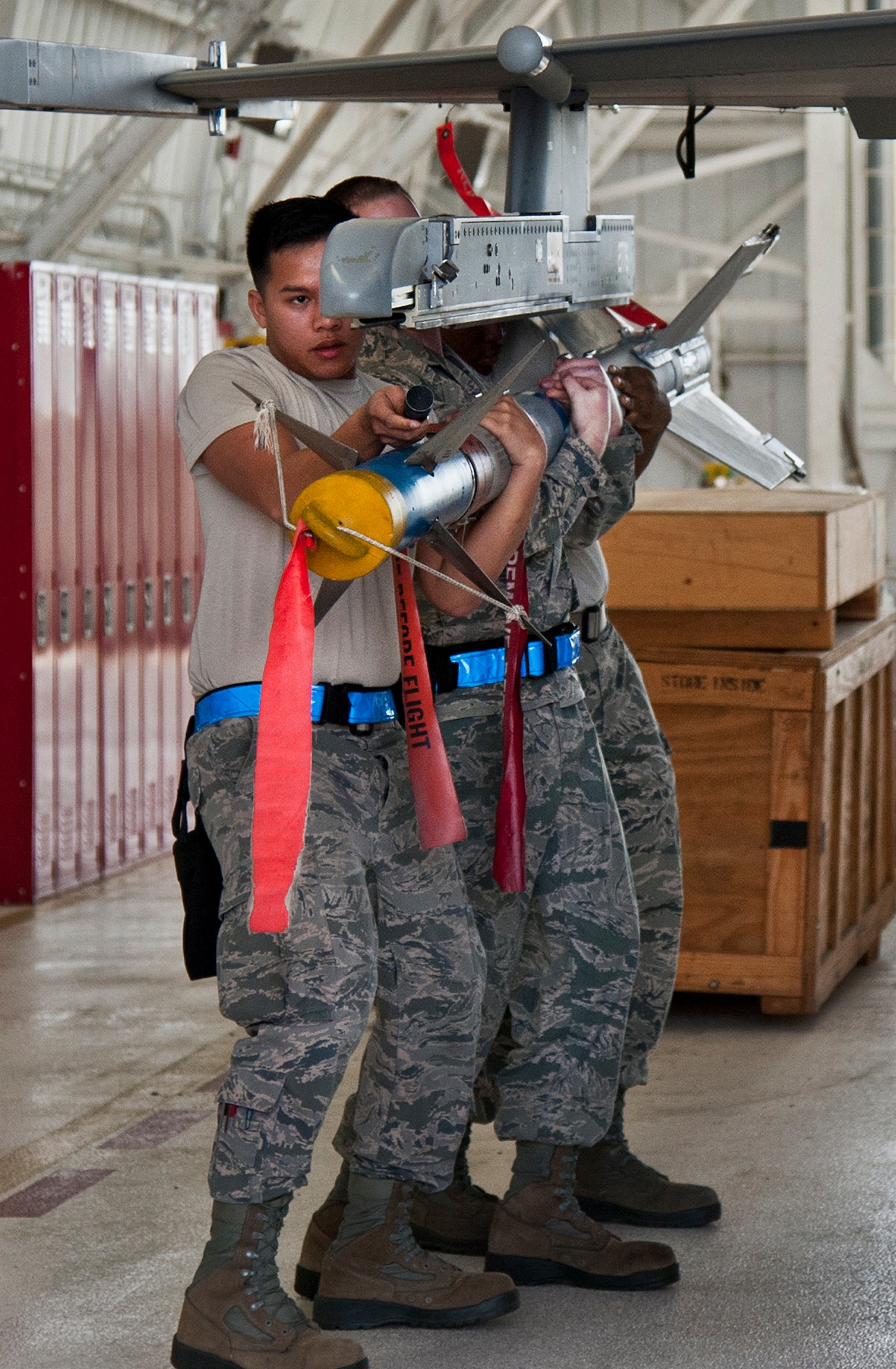 Airmen 1st Class Frederick Guaren and Troy Carpenter and Staff Sgt. Mark Blinn, of the 96th Aircraft Maintenance Squadron Blue, position a AIM-9LM for loading onto the F-16 Fighting Falcon, during the 96th Maintenance Group’s quarterly weapons load crew competition Sept. 26 at Eglin Air Force Base, The AMU Blue team won the competition.  (U.S. Air Force photo/Chrissy Cuttita)