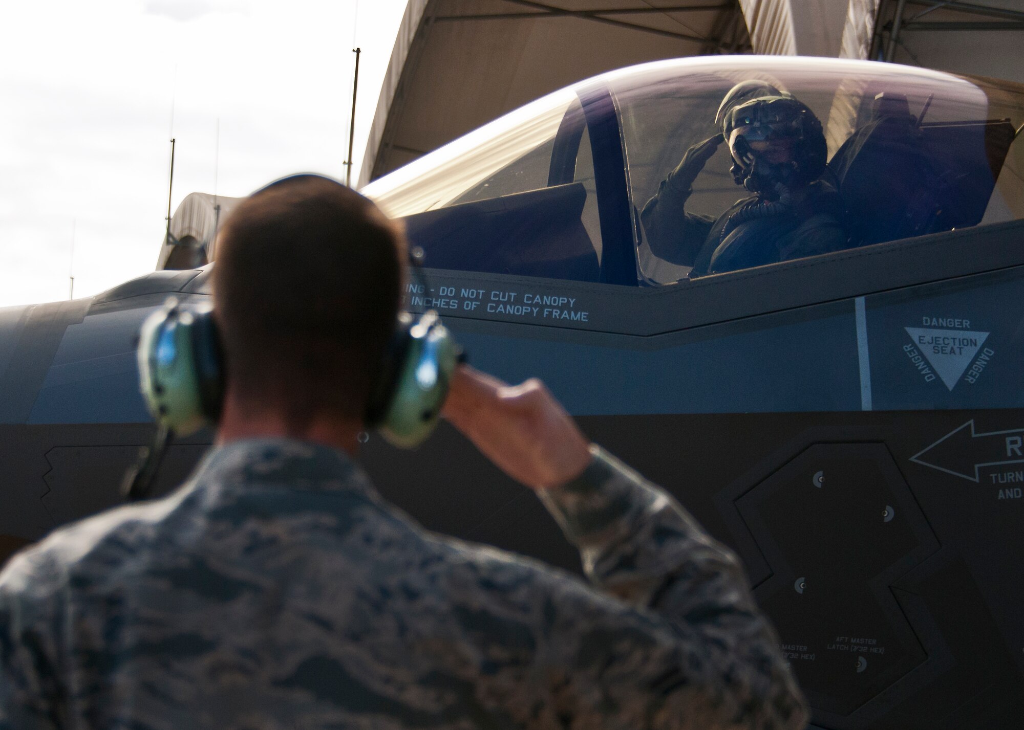 Maj. Gen. Jay Silveria, U. S. Air Force Warfare Center commander, salutes his crew chief, Airman 1st Class John Patterson, 33rd Aircraft Maintenance Squadron, as he begins taxiing for his final qualifying flight in the F-35A Lightning II Sept. 26 at Eglin Air Force Base, Fla.  Silveria became the first general officer in the Department of Defense to qualify in the fifth generation fighter.  He completed his training with back-to-back flights and hot pit refueling.  (U.S. Air Force photo/Samuel King Jr.)