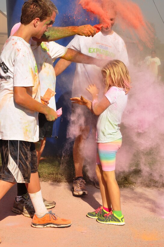 Members of Team Offutt dump color pouches on one another at the finale of the Color Explosion Fun Run Sept. 27 at the Base Lake. The run was open to all Team Offutt members and their families. (U.S. Air Force photo by Staff Sgt. Rachelle Blake)


