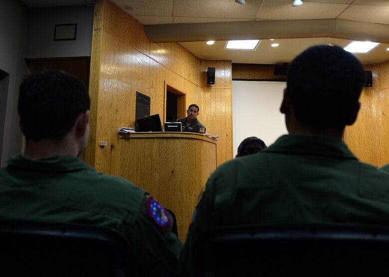 ALTUS AIR FORCE BASE, Okla. – U.S. Air Force Staff Sgt. Jose Prado, 54th Air Refueling Squadron instructor boom operator, trains 97th Training Squadron students in the 54th auditorium, Sept. 23, 2014. Instructors from the 54th briefed the students on how to safely evacuate a KC-135 Stratotanker refueling aircraft in an emergency situation. (U.S. Air Force photo by Senior Airman Franklin R. Ramos/Released)