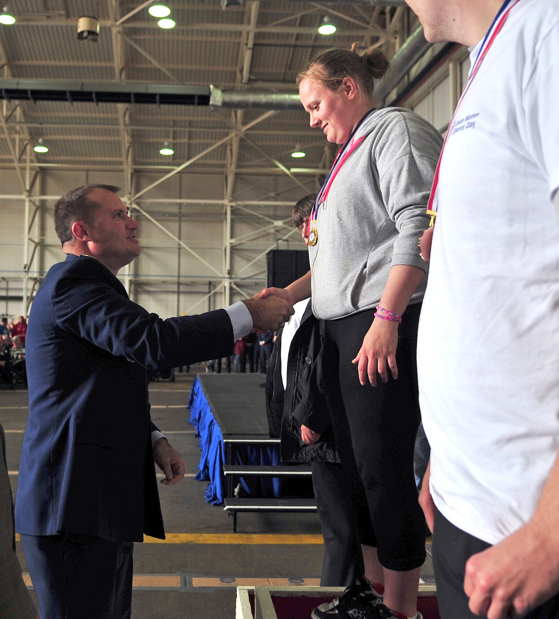 U.S. Air Force Col. Kenneth T. Bibb Jr., 100th Air Refueling Wing commander, left, congratulates a Joan Mann Special Sports Day athlete, during the JMSSD event Sept. 27, 2014, on RAF Mildenhall, England. JMSSD is an event dedicated to special-needs adults and children from around England. (U.S. Air Force photo/Senior Airman Christine Griffiths/Released) 