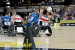 Air Force Staff Sgt. Mark Johnson passes the ball around Italy's Armondo Marco Iannuzzi during the United State's 22-4 victory over Italy in a wheelchair rugby pool match at the 2014 Invictus Games. Invictus Games is an international competition that brings together wounded, injured and ill service members in the spirit of friendly athletic competition. American Soldiers, Sailors, Airmen and Marines are representing the United States in the competition which is being held in London Sept. 10-14. (U.S. Navy photo by Mass Communication Specialist 2nd Class Joshua D. Sheppard/Released)