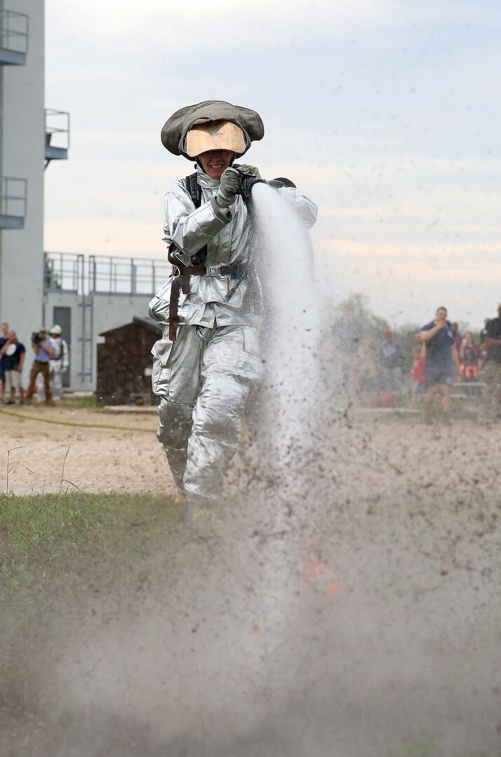 Senior Airman Kelyn Maunu, 802nd Security Forces Squadron patrolman, knocks over a cone with water pressure during the firefighter fitness challenge portion of the Battle of the Badges competition Sept. 27 at Joint Base San Antonio-Randolph’s Camp Talon. Firefighters and security forces members from Joint Base San Antonio locations have competed in Battle of the Badges for the past three years. The initiative was designed to build stronger bonds between the agencies and has become a tradition for the unit members, their families and friends. (U.S. Air Force photo by Johnny Saldivar)
